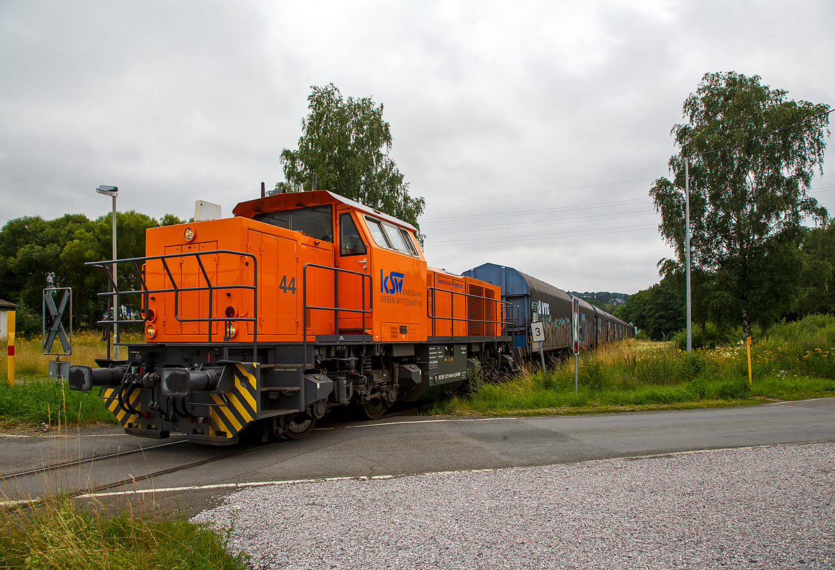 Die KSW 44 (92 80 1271 004-4 D-KSW) die MaK G 1000 BB der KSW (Kreisbahn Siegen-Wittgenstein) fährt am 16.07.2021 mit einem Coilzug auf der KSW-Privatbahnstrecke der Freien Grunder Eisenbahn (KSW NE447 / DB-Nr. 9275) von Herdorf nach Neunkirchen-Salchendorf zum Pfannenberg. Hier fährt der Zug gerade durch Neunkirchen-Struthütten (Im Wiesengrund). Ich stehe beim Bü Alter Weg.