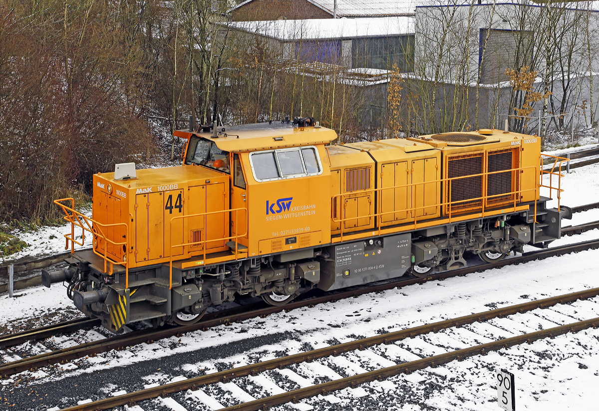 
Die Lok 44 (92 80 1271 004-4 D-KSW) der KSW (Kreisbahn Siegen-Wittgenstein), eine MaK G 1000 BB, rangiert am 30.01.2015 in Herdorf auf den KSW-Gleisen. 

Die Lok 44 wurde 2003 unter der Fabriknummer 1001462 bei Vossloh gebaut und am 05.01.2004 an die SK - Siegener Kreisbahn GmbH geliefert, welche ab Ende 2004 nun als Kreisbahn Siegen-Wittgenstein (KSW) firmiert.

Die G 1000 ist eine vierachsige dieselhydraulische Lokomotive
für den schweren Rangier- und leichten Streckendienst. Die zuverlässige Vielzwecklokomotive ist mit modernster Technik ausgestattet und erfüllt daher die neuesten Vorschriften des Unfallschutzes. Die Anwendungsbreite der Lokomotive reicht vom leichten Rangierdienst in Einzeltraktion über den Einsatz als Streckenlokomotive in Mehrfachtraktion bis hin zum schweren Rangierdienst. 

Mit der MaK G 1000 BB wird seit dem Jahr 2002 eine Lok für den Leistungsbereich unterhalb der G 1206 angeboten. Sie basiert auf der G 800 BB, von der außer dem kompletten Fahrwerk und Rahmen auch das Führerhaus und der hintere Vorbau übernommen wurden. Deutlich anders ist dagegen der vordere Vorbau, in dem Platz für den größeren Dieselmotor geschaffen wurde.


Technische Daten
Spurweite:  1435 mm
Achsfolge:  B´B´
Länge über Puffer: 14.130 mm
Drehzapfenabstand: 6.700 mm
Radsatzabstand im Drehgestell:  2.400 mm
größte Breite:  3.080 mm
größte Höhe über Schienenoberkante:  4.225 mm
Raddurchmesser neu:  1.000 mm
kleinster befahrbarer Gleisbogen:  60 m
Dienstgewicht: 80 t
Bremse:  Radscheibenbremse (Knorr), auf alle Räder wirkend
hydrodynamische Bremse
Bremsgewichte G/P: 65 t/96 t
Kraftstoffvorrat:  3000 l
    
Motor:  MTU 8V 4000 R41L
Leistung:  1.100 kW (1.475 PS)
Drehzahl:  1860 1/min
    
Strömungsgetriebe: Voith L4r4
Höchstgeschwindigkeit:  100 km/h
    
Seit 2002 wurden 103 G 1000 gebaut (Stand 01.01.2015).