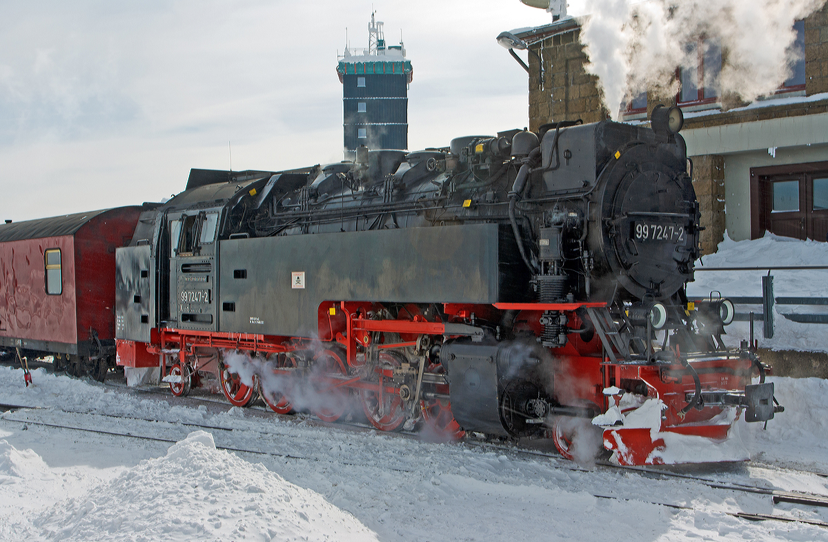 
Die Neubau-Dampflok der Harzer Schmalspurbahnen HSB 99 7247-2 (ex DR 099 157-0, 99 0247-9, 99 247) erreicht am 23.03.2013 den Bahnhof Brocken (1.125 m ü.NN),  welcher sich knapp unterhalb des 1.142m hohen Gipfel des Brocken befindet. 

Die meterspurige Dampflok wurde 1957 bei LKM (VEB Lokomotivbau Karl Marx Babelsberg unter der Fabriknummer 134028 gebaut und als DR 99 247 an die Deutsche Reichsbahn geliefert. Zum 01.07.1970 erfolgte die Umzeichnung in DR 99 7247-2, nachdem man sie 1980 auf Ölfeuerung umbaute wurde sie als DR 99 0247-7 bezeichnet. Da die Ölfeuerung nicht zum Vorteil der Maschinen war und Öl in der DDR knapp war wurde sie (wie alle Loks) 1983 wieder auf Kohlefeuerung zurück gebaut und nun wieder als DR 99 7242-2 bezeichnet. Ab dem 01.01.1992 wurden die Lok noch als DR 099 157-0 um bezeichnet, bis am 01.02.1993 in die HSB überging, welche dann wieder die alte DR-Bezeichnungen verwendete.