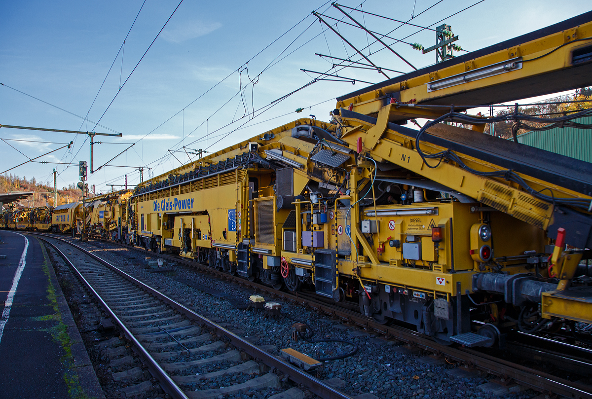 Die Plasser & Theurer Planumssanierungs- und Reinigungsmaschine RPM-RS-900 „Katharina die Große“ der SPITZKE SE (Großbeeren), Schweres Nebenfahrzeug Nr. D-SPAG 99 80 9415 004 – 1 (ex 97 19 35 501 18-1), am 09.11.2021 bei einer Zugdurchfahrt in Betzdorf (Sieg) in Richtung Siegen.

Hier als Detailbild die Stopf-u.  Einschotterungsmaschine SEM, (P&T Fabriknummer 4799), mit:
• Flexibler Einschotterung mittels Schwenkförderband mit Höhensteuerung.
• Integrierte, mittels Satellit kontinuierlich arbeitende Stopfmaschine mit 16 Stopfwerkzeugen und mit Vorkopfverdichtung.
• Nachlaufende integrierte Kehrwelle (am Übergabewagen)