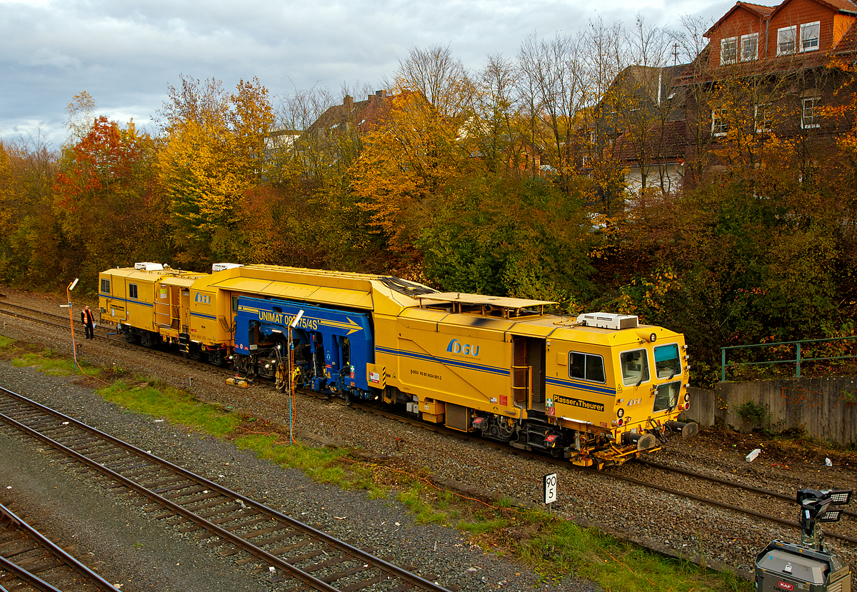 
Die Plasser & Theurer Universalstopfmaschine UNIMAT 09-475/4S, Schweres Nebenfahrzeug Nr. D-DGU 99 80 9424 001-2, ist am 27.10.2020 zwischen Neunkirchen und Herdorf auf der Hellertalbahn (KBS 462) im Einsatz. Hier in Herdorf beim 2. Durchgang auf den letzten Metern.

Die UNIMAT 09-475/4S eine Kombinierte Gleis- und Weichenstopfmaschine wurde 2011 von Plasser & Theurer unter der Fabriknummer 1358 gebaut und an die DGU geliefert.

TECHNISCHE DATEN der Unimat 09-475/4S:
Spurweite: 1.435 mm
Länge über Puffer: 31.540 mm
Drehzapfenabstände: 6.400 mm / 3.500 mm / 14.000 mm
Achsabstände im Drehgestell: 1.800 mm
Lauf- und Triebraddurchmesser: 920 mm (neu)
Anzahl der Achsen: 8
Gesamtwicht: 122,6 t
Anhängelast: 50 t
Höchstgeschwindigkeit: 100 km/h
kleinster befahrbarer Radius: R 150
zul. Streckenklasse: D4 und höher
zur Mitfahrt zugelassene Personen: 5