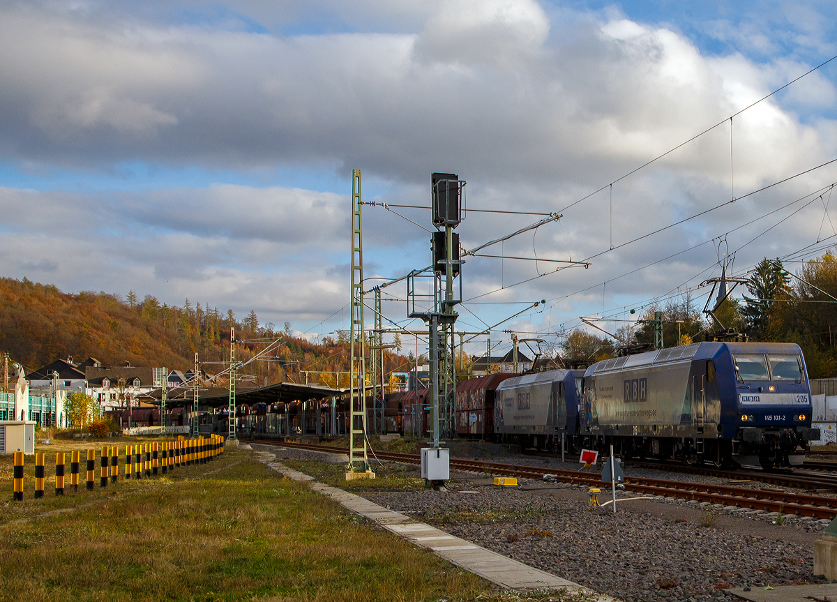 Die RBH 205 bzw. RBH 145 101-2 (91 80 6145 101-2 D-RBH) und RBH 218 (an die RBH vermietete DB 145 027-9 (91 80 6145 027-9 D-DB)) fahren am 06.11.2021 in Doppeltraktion einen Kohlenzug (offene Schüttgutwagen der Gattung Falns) durch den Bf. Betzdorf (Sieg) in Richtung Köln.

Vorne die RBH 145 101-2 wurde 2001 von Bombardier in Kassel unter der Fabriknummer 33849 gebaut und an die RBH. Die 145 027-9 wurde 1999 von ABB Daimler-Benz Transportation GmbH (Adtranz) in Kassel unter der Fabriknummer 33344 gebaut und an die DB geliefert, seit Sommer 2018 ist sie an die RBH Logistics GmbH in Gladbeck vermietet.

Die RBH Logistics ist ein Tochterunternehmen der DB Cargo Deutschland AG und die Nachfolgegesellschaft von Werks-, Zechen- und Hafenbahnen im Raum der Bergwerksdirektion Recklinghausen. Durch die verschiedenen Firmenzusammenschlüsse und -aufteilungen ergab sich seit 1913 eine wechselvolle Geschichte. Das heute als Teil des Firmennamens genutzte Akronym RBH stand einige Jahre für die RAG-Bahn- und Hafenbetriebe und wurde beim Verkauf von dieser an die Railion Deutschland im Jahr 2005 beibehalten. Nach damaliger Angabe des neuen Eigentümers stehen die Buchstaben R, B und H nun für die Kernkompetenzen des Unternehmens: Eisenbahnverkehr (Rail), Binnenschifffahrt (Barge) und Hafenumschlag (Harbour).
