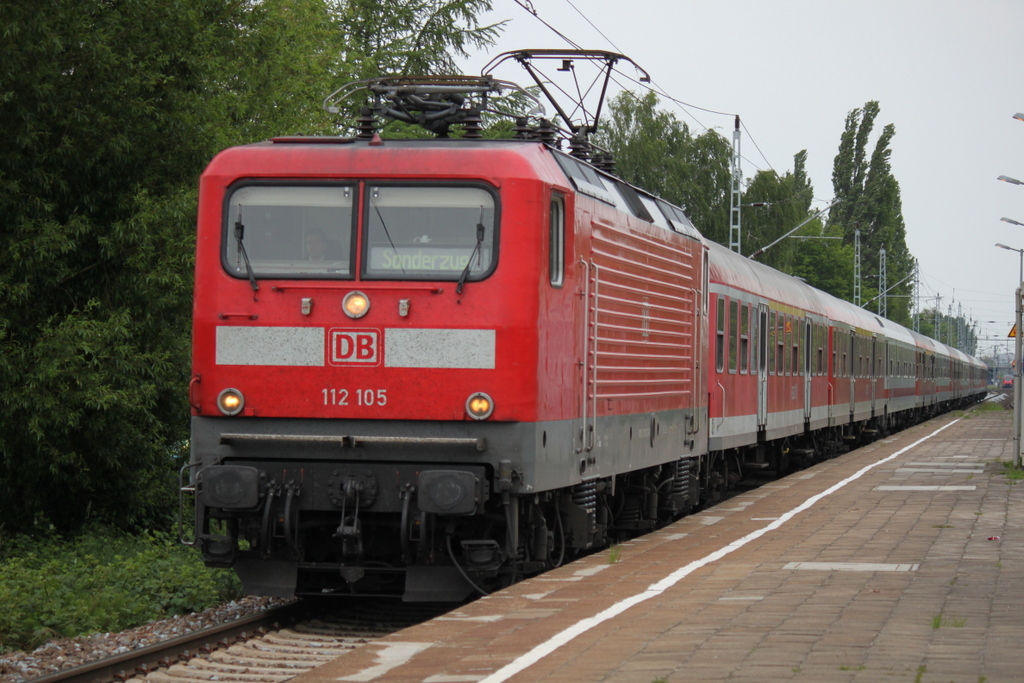 Die Rostocker 112 105-2 mit Sonderzug 13290 von Warnem�nde nach Berlin-Zoo bei der Durchfahrt am 28.05.2015 im Haltepunkt Rostock-Holbeinplatz