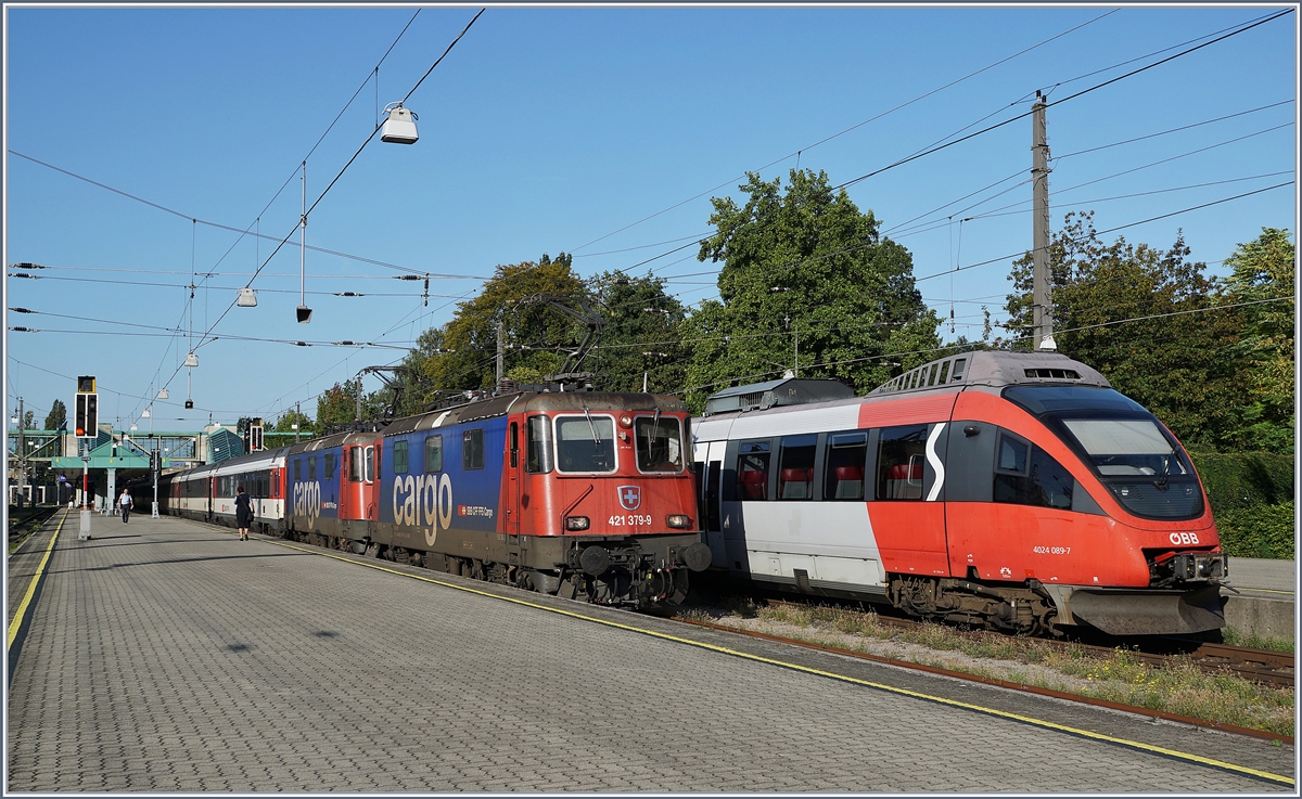 Die SBB Re 421 379-9 und eine weitere mit ihrem EC von Zürich nach München beim Halt in Bregenz. Recht im Bild steht der ÖBB ET 4024 098-7. 

16. Sept. 2019