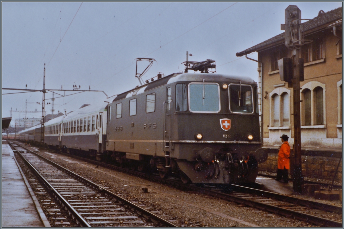 Die SBB Re 4/4 II 11232 wartet nach der bernahme des Hispania Express nach dem Fahrtrichtungswechsel in Delmont auf die Weiterfahrt nach Basel. Der Zug besteht aus zwei Teilen: dem IC/EC Hispania von Genve nach Hamburg und dem Nachtzug Port-Bou bzw. Cerbre - Basel (-Hamburg).

16. Sept. 1984 