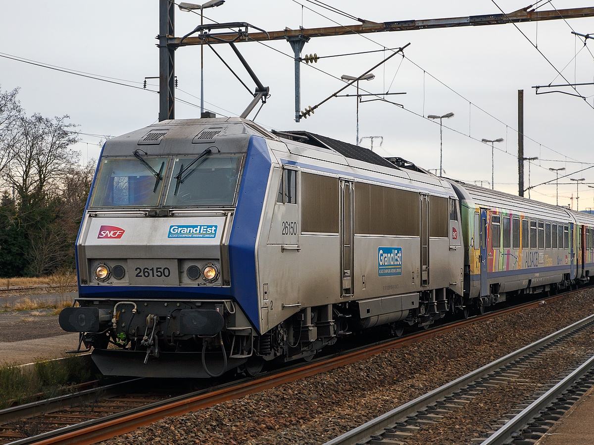 
Die SNCF TER Grand Est BB 26150  Sybic  erreicht mit dem TER96282 (Train Express Regional) nach Strasbourg am 29.12.2017 den (Bahnhof) Gare de Saint-Louis (Haut-Rhin).