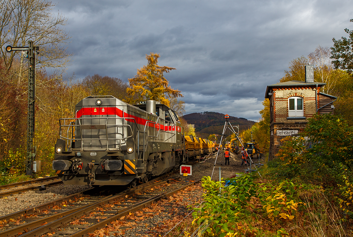 
Die Vossloh G 12 – 4120 001-7 „Karl August“ (92 80 4120 001-7 D-KAF) der KAF Falkenhahn Bau AG (Kreuztal) steht am 02.11.2020 mit einem Kippwagenzug (Kippwagen MK 45 DH „LW-Kipper“, der Gattung Rlps) auf Gleis 2 im Bahnhof Herdorf. Der Zug wird von einem ZW-Bagger mit dem Aushub (Altschotter) von Gleis 4 beladen. Der Altschotter  wird später zum Recycling nach Bochum abgefahren.  

Rechs das Stellwerk Herdorf Fahrdienstleiter (Hf).

Übrigens, die Lok trägt den Namen des Firmengründers Karl August Falkenhahn, der die Baufirma 1919 in Kreuztal gründete.