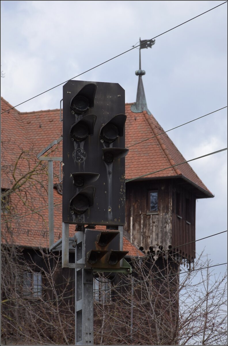 Dieser Tage streiken mal nicht Fahrzeuge, Weichen oder Signale im großen Kanton, sondern die Mitarbeiter.

Und weniger wehrhafte Signale werden bestreikt, die irgenwie gleich alt aussehen, wie das Kaufhaus dahinter aus dem Jahr 1188. Dunkle Signale sieht man jedenfalls nicht alle Tage. Bahnhof Konstanz Richtung Norden. März 2023.