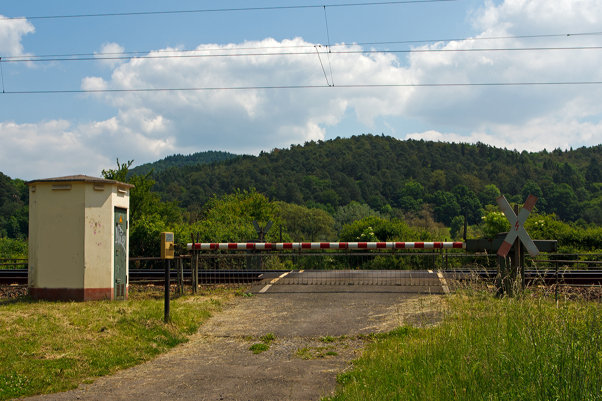 
Eigentlich nur ein Bahnübergang, der Bü km 127,660 bei Dillenburg am 02.06.2014.

Es handelt sich hierbei um eine Anrufschranke, da es nur ein wenig genutzter Bahnübergang an einem Wirtschaftsweg ist. Die Schrankenbäume sind hier grundsätzlich geschlossen und werden nur, sofern dies gefahrlos möglich ist, bei Bedarf geöffnet.

Wenn man den Bahnübergang passieren möchte, so meldet man sich über die Wechselsprechanlage (hier links von der Schranke) beim diensthabenden Schrankenwärter bzw. Fahrdienstleiter. Dieser öffnet dann, wenn es der Zugverkehr zulässt oder kündigt das Öffnen über die Wechselsprechanlage an. Da er den Bahnübergang nicht einsehen kann, wird man aufgefordert, die Räumung dem Wärter zu melden. Bevor er die Schranken wieder schließt, kündigt er das Schließen über die Wechselsprechanlage an. 

Langfristig sollen aus Gründen der Wirtschaftlichkeit Anrufschranken nicht mehr genehmigt werden, sie sollen sukzessive durch gesicherte Bahnübergänge durch Schrankenüberwachung oder eine Gefahrenraum-Freimeldeanlage sowie Rückstauerkennung gesichert werden.
