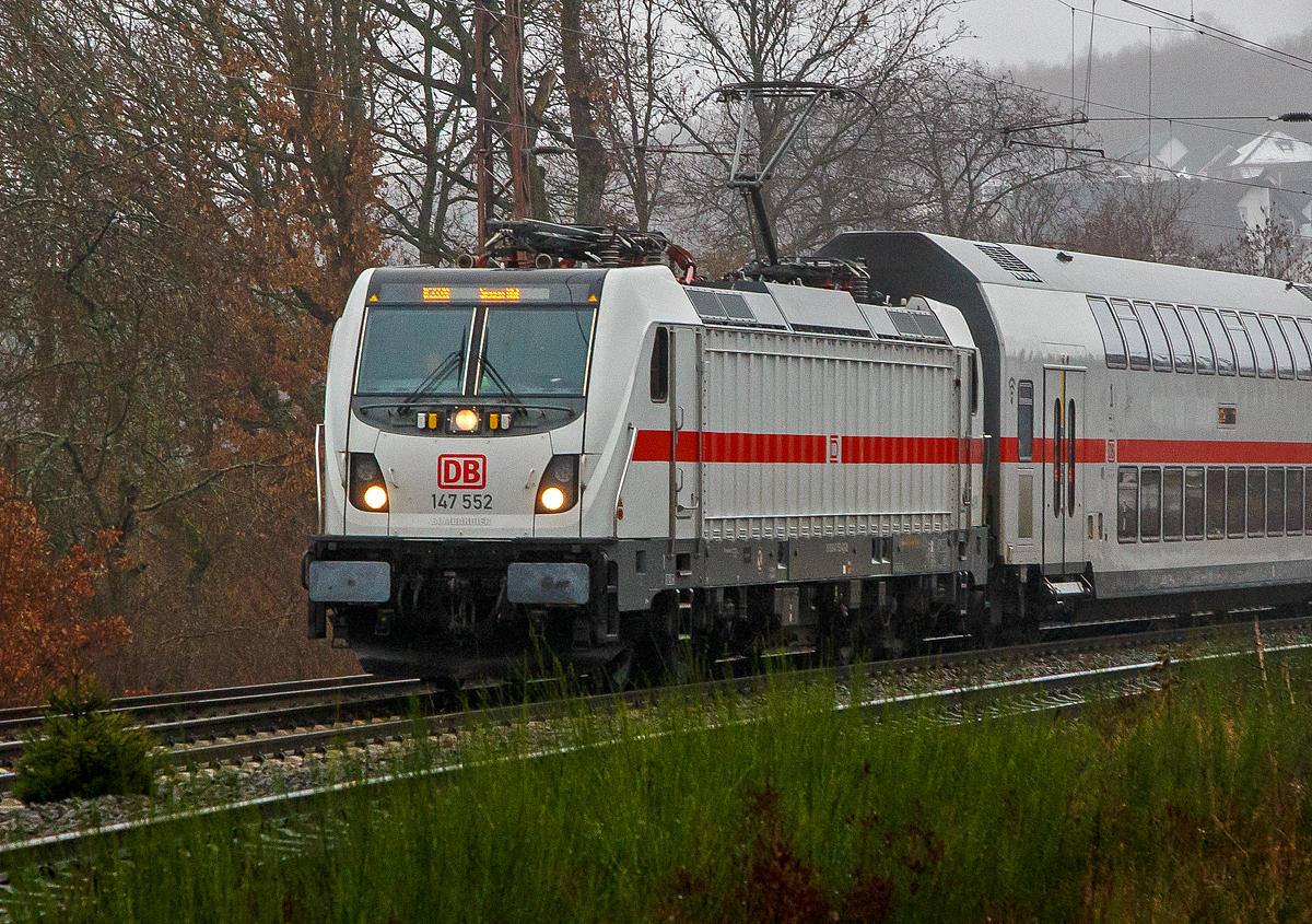 Eigentlich war heute kein Fotowetter, aber einen der ersten musste ich doch ablichten. 
Die 147 552 (91 80 6147 552-4 D-DB) der DB Fernverkehr AG fährt am 12.12.2021 mit dem IC2 (IC 2228) auf der Dillstrecke (KBS 445) durch Rudersdorf (Kr. Siegen) in Richtung Siegen. Zurzeit ist der Hbf Siegen Endstation, vermutlich ab 20.12.2012 ist es dann Hamm(Westf)Hbf.

Die TRAXX P160 AC3 wurde 2016 von Bombardier in Kassel unter der Fabriknummer 35224 gebaut und an die DB Fernverkehr AG geliefert. Sie hat die Zulassungen für Deutschland und die Schweiz, daher hat sie auch vier Stromabnehmer.

Die Deutsche Bahn hatte Mitte 2013 erstmals 20 Traxx P160 AC3 für DB Regio abgerufen. Die Maschinen (147 001–020) wurden nach rund zweijährigem Testlauf im Dezember 2016 nach Stuttgart ausgeliefert und absolvierten im Januar 2017 die ersten Einsätze. 

Im März 2015 rief die DB weitere 17 Traxx P160 AC3 ab, diesmal für die DB Fernverkehr AG, diese sollten mit zeitgleich nachbestellten Doppelstock-Intercity (IC2) eingesetzt werden, erhielten daher eine WTB-Steuerung. Angestrebt sind Zulassungen für Deutschland und die Schweiz, einschließlich ETCS-Level-2-Ausrüstung, zusätzlichen Stromabnehmern mit schmalen Paletten (1.450 mm), und seitlich angebrachten Videokameras als Rückspiegelersatz. Im Gegensatz zu den verkehrsroten Maschinen von DB Regio sind die als Baureihe 147.5 (551–567) bezeichneten Lokomotiven der  DB Fernverkehr in IC-Farbgebung (weiß mit verkehrsrotem Längsstreifen) lackiert, sie wurden bis Ende 2018 abgeliefert. Die Maschinen wurden mit Zielschildanzeigen über den Frontfenstern ausgerüstet.

TECHNISCHE DATEN:
Spurweite:  1.435 (Normalspur) 
Achsformel:  Bo’Bo’
Länge über Puffer:  18.900 mm 
Drehzapfenabstand: 10.440 mm
Höhe:  4.283 mm
Breite:  2.977 mm 
Treibraddurchmesser:  1.250 mm (neu) / 1.170 mm (abgenutzt)
Dienstgewicht:  87 t
Dauerleistung:  5.600 kW 
Höchstgeschwindigkeit:  160 km/h
Anfahrzugkraft:  300 kN
Stromsystem: 15 kV, 16,7 Hz ~ (25 kV, 50 Hz ~ möglich)
Bremse: bremsrechnergesteuerte elektrische Bremse, Druckluftbremse

Erstmals seit den TRAXX-Vorgängern AEG 12X respektive der Baureihe 101 von ABB Henschel wurde der Lokkasten nicht mit glatten Seitenwänden gefertigt. Konstruktiv deutlich günstiger, sind die Seitenwände der AC3 vertikal gesickt; stattdessen erhielten die Seitenflächen sogenanntem Flex-Panel, eine Vorrichtung zum Einspannen von Planen. Diese würden die Sicken verdecken, und wären kostengünstiger als Umlackierungen oder Umbeklebungen von Mietlokomotiven, zudem könnten die Halter auch Werbung anbringen.

Eine Variante „P189“ mit Hohlwellenantrieb und auf maximal 189 km/h gesteigerter Zulassung, wurde von Bombardier in Aussicht gestellt.
