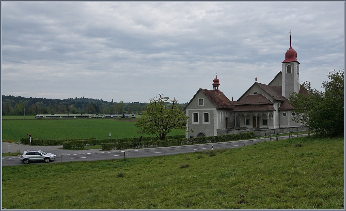 Ein BLS RABe 535  Lötschberger  und ein BLS RABe 525  NINA  auf der Fahrt von Luzern nach Bern/Langenthal kurz vor Malters bei der Kirche St. Jost in Blatten.
6. Mai 2017