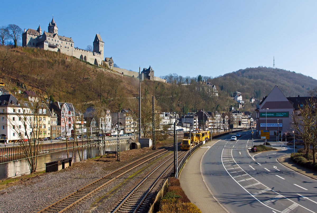 
Eine Stopfmaschine und eine Schotterplaniermaschinen der DGU - Deutsche Gleisbau Union (Koblenz), fahren am 08.03.2014 über die Ruhr-Sieg-Strecke (KBS 440) durch Altena in Richtung Kreuztal.

Oben auf dem Berg die Burg Altena.