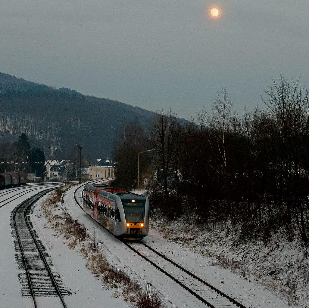 
Einen Tag später der gleicher Stelle der gleiche Triebwagen und Verbindung, nur mit fast vollen Mond...
Der HLB 127 bzw. VT 526 127  (95 80 0646 427-4 D-HEB / 95 80 0946 927-0 D-HEB / 95 80 0946 427-1 D-HEB) ein  Stadler GTW 2/6 der HLB (Hessische Landesbahn GmbH) fährt am 21.01.2016, als RB 96  Hellertalbahn   (HLB 61778) die Verbindung Dillenburg - Haiger - Neunkirchen - Herdorf - Betzdorf), hier erreicht er nun bald den Bahnhof Herdorf. 
Einen Gruß an den netten TF zurück.