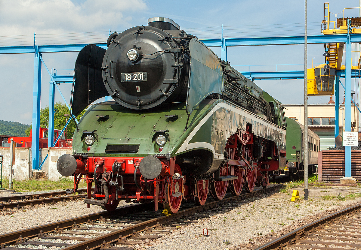 Einfach eine Schönheit....
Die 18 201 (ex DR 18 201 ex DR 02 0201-0) der Dampf Plus steht am 24.08.2013 im Dampflokwerk Meiningen (DLW).

Sie ist, mit einer Höchstgeschwindigkeit von 182,5 km/h, die schnellste betriebsfähige Dampflokomotive der Welt. Sie hat mit 2,3 m Durchmesser mächtig große Treibräder. Zudem ist sie ein Unikat, diese Lok gab und gibt es nur einmal auf der Welt.

Die Schnellzuglokomotive mit der Nummer 18 201 der Deutschen Reichsbahn entstand 1960 bis 1961 im Reichsbahnausbesserungswerk Meiningen aus Teilen der Henschel-Wegmann-Zug-Lokomotive 61 002, dem Schlepptender der 44 468 und Teilen der H 45 024 und einer Lokomotive der DR-Baureihe 41. Sie war eine der schnellsten betriebsfähigen Dampflokomotiven der Welt.

Die Motive für den Umbau waren zum einen, dass die bereits seit Jahren abgestellte 61 002 als Einzelstück kaum im Plandienst zu gebrauchen war, zum anderen, dass die VES-M Halle dringend Schnellfahrlokomotiven für eine Geschwindigkeit von mindestens 160 km/h benötigte, um Probefahrten mit für den Export bestimmten Reisezugwagen der einheimischen Waggonbau-Industrie durchzuführen. Mit ihren 2.300 mm großen Treibrädern bot sich die 1939 bei Henschel & Sohn gebaute 61 002 für einen solchen Umbau an. Der Umbau war von dem Leiter der Fahrzeugversuchsanstalt Halle Max Baumberg initiiert worden.

Von der 61 002 wurde der vordere Rahmenteil (Barrenrahmen) und das Trieb- und Fahrwerk bis zur dritten Kuppelachse übernommen. Der Rahmen für das hintere Bisselgestell, der hintere Kuppelkasten sowie die Außenzylinder stammten von der misslungenen Hochdrucklokomotive H 45 024. Der hintere Rahmen wurde in Anlehnung an den Rahmen der H 45 024 neu als Blechrahmen konstruiert und an den vorderen Barrenrahmen angeschweißt. Der Rahmen der H 45 024 konnte nicht verwendet werden, da dessen Wangenstärke von 100 mm nicht zu den 80 mm des Barrenrahmens der 61 002 passte.

Der Innenzylinder wurde durch eine Neukonstruktion ersetzt. Der Ersatz der Zylinder war notwendig, da die ursprüngliche Dampfmaschine der Baureihe 61 einen Druck von 20 bar erforderte, passende Kessel aber wegen Material- und Unterhaltungsproblemen keine ausreichende Lebensdauer erreichten. Als Dampferzeuger kam der Neubaukessel 39 E zum Einsatz, welcher auch in den Baureihen 03, 22 und 41 Verwendung fand. Der Tender war zuvor mit der 44 468 gelaufen. Die Lok erhielt auch, wie zu dieser Zeit üblich, einen Giesl-Ejektor.

Um die Maschine wieder unter Dampf zu setzen, gründeten der Unternehmer Christian Goldschagg und der Musiker Axel Zwingenberger zunächst die Initiative Rettet die 18 201 und anschließend die Dampf-Plus GmbH. Mit dem Geld dieser Firma wurde die Lok im Dampflokwerk Meiningen vollständig aufgearbeitet und am 4. April 2002 den Investoren übergeben. Dampf-Plus hatte als Geldgeber in diesem Zusammenhang mit dem DB Museum einen Kooperationsvertrag geschlossen, um die Investitionssumme durch Nutzungsrechte an der Lok mittels Vermarktungskonzepten gewinnbringend wieder einzuspielen und am Erhalt der 18 201 maßgeblich mitzuwirken. In der Folge kam es zu einem Streit über die Wahrung der Vertragsinhalte mit der Deutschen Bahn AG, wobei es auch darum ging, dass aus Sicherheitsgründen nur DB-Stammpersonal die Lokomotive bedienen durfte. Im März 2004 wurden die Kooperationsverträge endgültig aufgehoben, wobei die DB weiterhin auf ihr Recht der Personalgestellung pochte. Ab dem 28. Februar 2004 war Dampf-Plus Eigentümer der Lokomotive und versuchte in der Folge, die Lokomotive wieder zu verkaufen, um die Verluste des Unternehmens zu kompensieren.

Zwischen dem 30. April 2002 und dem 10. Juli 2005 war die traditionell in Grün lackierte Maschine in einer roten Sonderlackierung RAL 3003 (Rubinrot) unterwegs, die der Modellbahnhersteller Roco für diesen Zeitraum gesponsert hatte. Nach dieser Vermarktungskampagne erhielt 18 201 eine chromoxidgrüne Färbung RAL 6020.

Nach der Aufarbeitung war die unter Denkmalschutz stehende Lokomotive bis zum 30. April 2012 im Ringlokschuppen des ehemaligen Bahnbetriebswerks Nossen untergebracht und wurde danach in Wittenberg stationiert.

Von 2010 bis 2015 war sie durch die Deutsche Museums-Eisenbahn im nationalen Fahrzeugeinstellungsregister angemeldet. Seit 2015 ist die Lokomotive durch die Sonderzugveranstaltungen in Chemnitz registriert. Im Jahr 2005 ging die Lokomotive in das Privateigentum von Christian Goldschagg über, nachdem die Dampf-Plus GmbH die eigenständige Vermarktung aus wirtschaftlichen Gründen aufgeben musste. Goldschagg hat nach der Übernahme alle Mitarbeiter der Dampf-Plus GmbH entlassen, um die Lokomotive direkt über seinen Münchener Mietservice zu vermarkten.

Ende 2018 liefen bei der denkmalgeschützten Lok 18 201 sämtliche Fristen an Fahrwerk und Kessel nach acht Jahren seit der letzten Hauptuntersuchung aus. Am 1. September fand noch eine große Abschiedsfahrt statt. Die Lokomotive wurde zunächst unzugänglich in einem Lokschuppen Wittenberg konserviert abgestellt. Am 14. August 2019 wurde die 18 201 wegen Geschäftsaufgabe der Dampf-Plus GmbH an die WFL GmbH & Co. KG, Potsdam verkauft. Der neue Eigentümer WFL hat im November 2019 die Lokomotive in das AW Neustrelitz zur Erledigung von Teilgewerken unter anderem an der Bremsanlagen von Lok und Tender im Rahmen der notwendigen gesetzlichen Hauptuntersuchung zur Wiederinbetriebnahme überführen lassen. Im September 2020 kehrte sie aus dem AW Neustrelitz in ihr Heimat-BW Nossen zurück, wo nun die weiteren Arbeiten der Hauptuntersuchung zur Erlangung der neuen Zulassung im Streckendienst durchgeführt werden. Nach erfolgreicher Zulassung für den Betriebsdienst steht die Lokomotive für Sonderfahrten wieder zur Verfügung.

TECHNISCHE DATEN:
Spurweite: 1.435 mm (Normalspur)
Achsformel:  2’C1’
Gattung:  S 36.20
Länge über Puffer: 25.145 mm
Leergewicht: 102,5 t
Dienstgewicht: 113,6 t
Dienstgewicht mit Tender: 186,8 t (mit vollen Vorräten)
Höchstgeschwindigkeit: 182,5 km/h
Indizierte Leistung: 1.581 kW
Anfahrzugkraft: 	ca. 147 kN
Treibraddurchmesser: 	2.300 mm
Laufraddurchmesser vorn: 1.100 mm
Laufraddurchmesser hinten: 1.250 mm
Zylinderanzahl: 	3
Zylinderdurchmesser: 	520 mm
Kolbenhub: 660 mm
Kesselüberdruck: 16,3 bar
Anzahl der Heizrohre: 	112
Anzahl der Rauchrohre: 36
Heizrohrlänge: 5.700 mm
Rostfläche: 4,23 m²
Strahlungsheizfläche: 	21,3 m²
Rohrheizfläche: 	185 m²
Überhitzerfläche: 83,80 m²
Verdampfungsheizfläche: 206,30 m²
Tender: 2'2' T 34 + Zusatztender
Wasservorrat:  34,0 m³
Brennstoffvorrat: 13,5 m³  (Schwer-Öl)
Zugheizung: Dampf 
