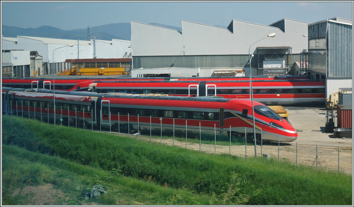 Fr mich einer der schnsten Hochgeschwidigkeitszge der letzen Jahre: Der FS ETR 400  Frecciarossa 1000  im Werkgelnde von Pistoia am 21. April 2015. 
(Foto durchs Fenster des RE nach Fireneze).
