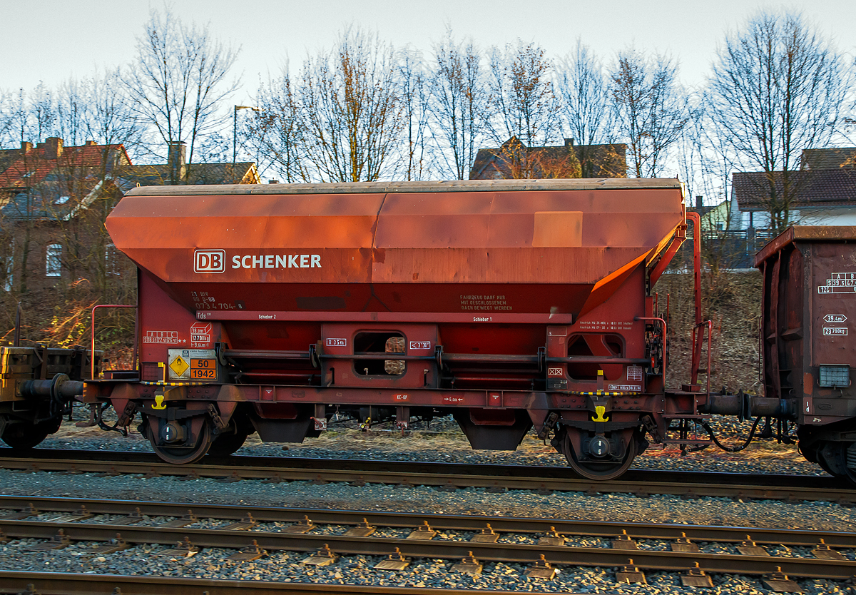 Gedeckter Schttgutwagen mit dosierbarer Schwerkraftentladung und zwei Radstzen 21 80 0734 704-8 D-DB, der Gattung Tds 938, der DB Cargo AG am 14.02.2017 in Herdorf, im Zugverband auf dem Rbf der KSW.

Der Wagen trgt auerdem einen Aufkleber der Firma YARA Rostock, das zum norwegischen Konzern Yara International gehrt. Yara ist ein Hersteller und Anbieter von Chemikalien und Industriegasen wie Dnger, Harnstoff, Nitraten und Ammoniak. Das Unternehmen entstand 2004 durch Abtrennung vom Unternehmen Hydro Agri, einem Firmenbereich von Norsk Hydro.

Die Wagen besitzen eine gleisseitige, dosierbare Entladeeinrichtung. Ein Innenanstrich erhht bei den meisten der Fahrzeuge den Gebrauchswert, insbesondere durch den Schutz vor Verunreinigungen, Mglichkeiten des Transportes von Lebensmitteln, gnstigeres Entladeverhalten (Rutschverhalten) bei schwer flieenden Gtern sowie durch verbesserten Korrosionsschutz bei aggressiven Ladegtern.

Der Wagen ist fr den Transport von nsseempfindlichen Schttgtern aller Art, wie z. B. Salze und Dngemittel, vorgesehen. Sie besitzen eine gleisseitige, dosierbare Entladeeinrichtung. Ein Innenanstrich erhht bei den meisten der Fahrzeuge den Gebrauchswert, insbesondere durch den Schutz vor Verunreinigungen, Mglichkeiten des Transportes von Lebensmitteln, gnstigeres Entladeverhalten (Rutschverhalten) bei schwer flieenden Gtern sowie durch verbesserten Korrosionsschutz bei aggressiven Ladegtern. Der Transport grobkrniger oder kantiger, schwerer Gter (z. B. Kies, Schlacke, Schotter) ist wegen einer mglichen Beschdigung der Innenbeschichtung nicht zulssig.

Das Untergestell und der Wagenkasten sind als Schweikonstruktion unter Verwendung von Walzprofilen und Blechen hergestellt. Beide Teile sind miteinander verschweit. Der Wagen besitzt zwei Bhnen, die von beiden Seiten zugnglich sind. Beide Bhnen sind mit einer Sprossenleiter versehen. Die Arbeitsbhne ist mit Handhebeln zur Bettigung der Wlbschieber, mit dem Handrad zur ffnung des Daches und teilweise mit einer Feststellbremse und Notbremshahn ausgerstet. Der Neigungsgrad des trichterfrmigen Wagenkastens ermglicht eine restlose selbstttige Entladung. Die Entladung des Wagens erfolgt ber Wlbschieber. Der Wagen ist mit einem einschaligen Hubschwenkdach ausgerstet. Das Dach wird vor dem Schwenken angehoben und dann seitlich abgeschwenkt, wobei die gesamte Breite der Beladeffnung freigegeben wird. Im geschlossenen Zustand ist das Dach gegen unbeabsichtigtes Verschwenken gesichert.

In diesen Wagen wird Ammoniumnitrat (Gefahrgutnummer 50/1942) zur Sprengstoff Herstellung zur Fa. Dynamit Nobel Defence nach Burbach-Wrgendorf gefahren (hier ist er leer).  Ammoniumnitrat ist der Stoff  von dem ca. 2.750 Tonnen im Hafen von Beirut am 4. August 2020 explodierten und zur der bekannten gewaltigen Explosionskatastrophe fhrten. 

TECHNISCHE DATEN:
Spurweite: 1.435 mm
Achsanzahl: 2
Lnge ber Puffer: 9.640 mm
Achsabstand: 6.000 mm
Laufraddurchmesser: 1.000 mm (neu)
Wagenhhe: 4.198mm
Gre der Beladeffnung Lnge x Breite: 8.000 x 1.200 mm
Laderaum: 38 m
Eigengewicht: 12.700 kg
Hchstgeschwindigkeit: 100 km/h (beladen) / 120 km/h (leer)
Maximales Ladegewicht: 26,5 t  ab Streckenklasse C
Kleinster bef. Gleisbogenradius: 35 m
Bauart der Bremse: KE-GP
Intern. Verwendungsfhigkeit: RIV