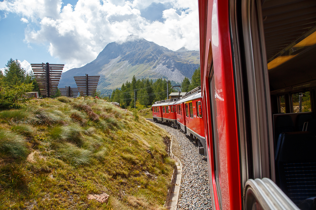Geführt von den beiden RhB ABe 4/4 III Triebwagen 54  Hakone  und  56  Corviglia  fährt der RhB-Regionalzug nach Tirano am 06.09.2021 von Ospizio Bernina hinab nach Alp Grüm.
