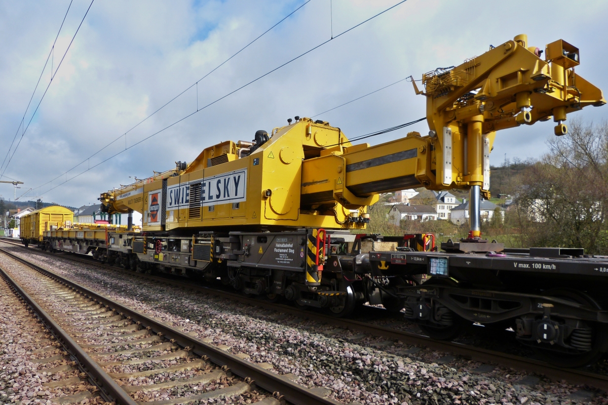 Gleisbauschienenkran KRC 1600, schweres Nebenfahrzeug im Transportzug eingereiht, (D-SWIE 99 80 9419 011-8), Eigengewicht 128 t, Max 100 km/h, (bei Selbstfahrt max 19 km/h), Bj. 2013, Bau Nr: MT 2011170177, steht zum Wechseln von 3 Weichen in der Nhe des Bahnhofs von Wilwerwiltz bereit. 12.04.2021