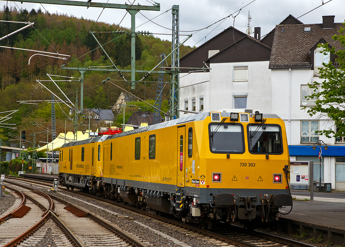 Glück für den Fotografen, das der Schienenprüfzug Hp 0 hatte....
Der Plasser & Theurer Schienenprüfzug (der Bauart SPZ 3) 719 302 / 720 302 (99 80 9160 005-1D-DB / 99 80 9360 008-3 D-DB) der DB Netz AG haete am 10.05.2021 im Bahnhof Betzdorf (Sieg) Hp 0, nun fährt er in Richtung Siegen weiter.

Der Schienenprüfzug wurde 2017 von Plasser & Theurer in Linz (A) unter der Fabriknummer 6048 (SPZ-STW) und  6049 (SPZ-ATW) gebaut.

Um Schäden am Oberbau frühzeitig zu erkennen, setzt die Deutsche Bahn AG verschiedene Prüfzüge der Baureihen 719 und 720 ein. Mittels zweier zerstörungsfreier Prüfverfahren werden die Schienen auf Schädigungen untersucht. Bei der Ultraschallprüfung können Materialfehler durch Materialermüdung innerhalb der Schiene bis zum Schienenfuß erkannt werden. Mit der Wirbelstromprüfung wird der Schienenkopf geprüft. 

Die Schienenprüfzüge der BR 719.3/720.3 wurden ab 2015  von Plasser & Theurer in Linz (A) gebaut. Diese dritte Messtriebwagengeneration entstand in modularisierter Bauweise. Sie basiert auf einer ein- und zweiteiligen Messwagenfamilie, die Ende 2012 von der DB bestellt wurde. Die Schienenprüfzüge sind zweiteilig ausgeführt und bestehen aus einem allachsgetriebenen Trieb- (ATW) und einem Steuerwagen (STW). Beide Wagen sind 23 Meter lang. Der ATW hat ein Eigengewicht von 81 t, der STW 67 t. Der Triebzug hat eine Höchstgeschwindigkeit von 140 km/h.
Unter dem Bodenrahmen des Steuerwagens sind zwischen den Drehgestellen ein absenkbarer Messwagen und zwei Wasserbehälter für die ZfP-Sensorik aufgehängt. Auf dem Dach des Triebwagens sitzt ein Messstromabnehmer. Als Antrieb dienen zwei Deutz-Dieselmotoren. Im hinteren Teil des Triebwagens gibt es eine klimatisierte Küche mit Mikrowelle, Herd, Spüle, Tisch und Sitzecke mit Wifi sowie eine Toilette. Im Steuerwagen sind neben dem Beobachtungsstand mit neun Monitoren eine Werkstatt mit Ersatzteillager und Kalibriergeräten, Schaltschränke mit Messtechnik, vier Schlafabteile und der Führerstand 1 untergebracht. Die Ultraschall- und Wirbelstrommesstechnik wurde von der Firma PLR Magdeburg geliefert. 
