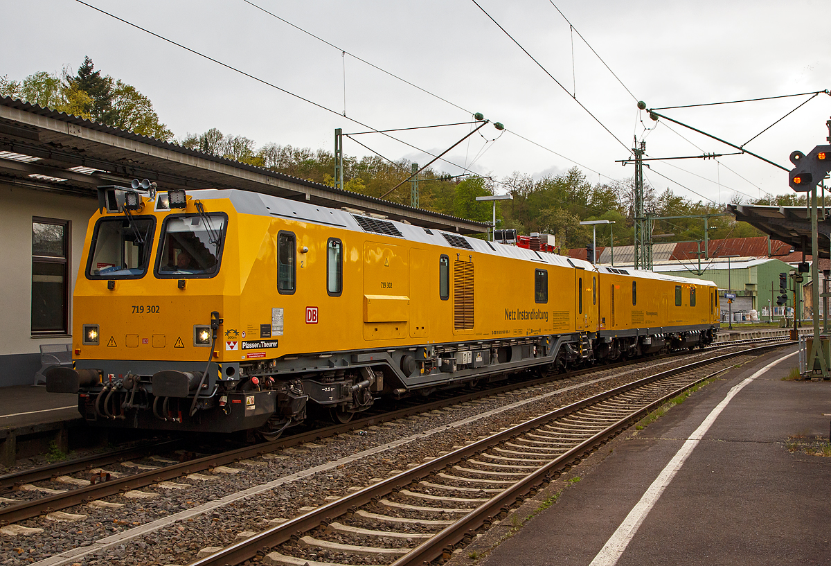 Glück für den Fotografen, das der Schienenprüfzug Hp 0 hatte....
Der Plasser & Theurer Schienenprüfzug (der Bauart SPZ 3) 719 302 / 720 302 (99 80 9160 005-1D-DB / 99 80 9360 008-3 D-DB) der DB Netz AG haete am 10.05.2021 im Bahnhof Betzdorf (Sieg) Hp 0, nun fährt er in Richtung Siegen weiter.

Der Schienenprüfzug wurde 2017 von Plasser & Theurer in Linz (A) unter der Fabriknummer 6048 (SPZ-STW) und  6049 (SPZ-ATW) gebaut.

Um Schäden am Oberbau frühzeitig zu erkennen, setzt die Deutsche Bahn AG verschiedene Prüfzüge der Baureihen 719 und 720 ein. Mittels zweier zerstörungsfreier Prüfverfahren werden die Schienen auf Schädigungen untersucht. Bei der Ultraschallprüfung können Materialfehler durch Materialermüdung innerhalb der Schiene bis zum Schienenfuß erkannt werden. Mit der Wirbelstromprüfung wird der Schienenkopf geprüft. 

Die Schienenprüfzüge der BR 719.3/720.3 wurden ab 2015  von Plasser & Theurer in Linz (A) gebaut. Diese dritte Messtriebwagengeneration entstand in modularisierter Bauweise. Sie basiert auf einer ein- und zweiteiligen Messwagenfamilie, die Ende 2012 von der DB bestellt wurde. Die Schienenprüfzüge sind zweiteilig ausgeführt und bestehen aus einem allachsgetriebenen Trieb- (ATW) und einem Steuerwagen (STW). Beide Wagen sind 23 Meter lang. Der ATW hat ein Eigengewicht von 81 t, der STW 67 t. Der Triebzug hat eine Höchstgeschwindigkeit von 140 km/h.
Unter dem Bodenrahmen des Steuerwagens sind zwischen den Drehgestellen ein absenkbarer Messwagen und zwei Wasserbehälter für die ZfP-Sensorik aufgehängt. Auf dem Dach des Triebwagens sitzt ein Messstromabnehmer. Als Antrieb dienen zwei Deutz-Dieselmotoren. Im hinteren Teil des Triebwagens gibt es eine klimatisierte Küche mit Mikrowelle, Herd, Spüle, Tisch und Sitzecke mit Wifi sowie eine Toilette. Im Steuerwagen sind neben dem Beobachtungsstand mit neun Monitoren eine Werkstatt mit Ersatzteillager und Kalibriergeräten, Schaltschränke mit Messtechnik, vier Schlafabteile und der Führerstand 1 untergebracht. Die Ultraschall- und Wirbelstrommesstechnik wurde von der Firma PLR Magdeburg geliefert. 
