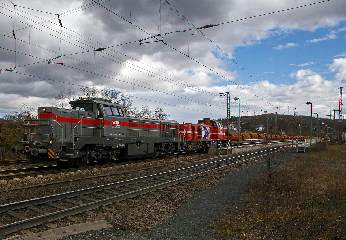 Im Doppelpack, ob man von einer Doppeltraktion sprechen ist mit nicht ganz klar, glaube aber nicht...
Die Vossloh G 12 – 4120 001-7 „Karl August“ (92 80 4120 001-7 D-KAF) und die Vossloh G 1000 BB - 271 022-6 „Charlotte“  (92 80 1271 022-6 D-KAF), ex HGK DH 49, beide von der KAF Falkenhahn Bau AG (Kreuztal) fahren am 11.03.2021, mit einem sehr langen Güterzug durch Rudersdorf (Kreis Siegen) in nördlicher Richtung, vermutlich Richtung Heimat Bf Kreuztal. Im Zugverband waren vorne einige mit Kies beladene KAF Kippwagen MK 45 DH „LW-Kipper“ der Gattung Rlps, dann etliche leere 2-achsiger Flachwagen für Schotter und Sand der Gattung NS Klmos 702 von Railpro und am Zugende noch vier 2-achsige Schüttgutwagen für Schotter der Gattung NS Fccpps von Railpro.

Von der Vossloh G 12 – 4120 001-7 „Karl August“ sind hier schon Daten und der Lebenslauf vorhanden, daher nur den Lebenslauf der Vossloh G 1000 BB - 271 022-6 „Charlotte“:
Die G 1000 BB wurde 2005 von Vossloh in Kiel unter der Fabriknummer 5001568 gebaut. Im Jahr 2006 wurde sie an die MRCE - Mitsui Rail Capital Europe B.V. verkauft, die die Lok an die HGK - Häfen und Güterverkehr Köln AG in Köln (HGK DH 49) vermietete, wo sie bis unter der NVR-Nummer 92 80 1271 022-6 D-DISPO fuhr. Danach hatte sie bis zum Verkauf im Jahr 2017 an die northrail GmbH in Hamburg, mehrere Mietstation. Von 2017 fuhr sie unter der NVR-Nummer 92 80 1271 022-6 D-NRAIL bis sie 2020 an die Michael Bugdoll Bau- und Sicherungsarbeiten e. K. in Dorsten ging und als 92 80 1271 022-6 D-MBBAU fuhr. 

Zum 01.01.2021 wurde sie an die KAF Falkenhahn Bau AG in Kreuztal verkauft und hört nun auf den Namen „Charlotte“ (92 80 1271 022-6 D-KAF).