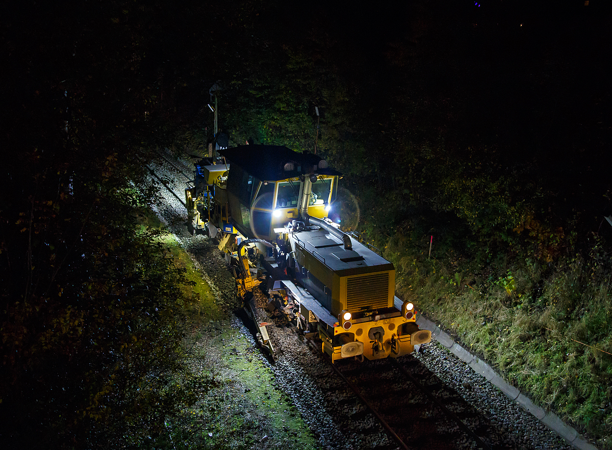 
Im Gleisbau wird Tag und Nacht gearbeitet, wie hier beim 3. Durchgang beim Stopfen  der Hellertalbahn (KBS 462) zwischen Neunkirchen und Herdorf. Die Plasser & Theurer Schotterverteil- und Planiermaschine SSP 110 SW, Schweres Nebenfahrzeug Nr. D-DGU 99 80 9425 068-0, ex 97 16 46 516 18-9 D-DGU (ex Hering Gleisbau, ex Volker-Rail), folgt hier am Abend des 27.10.2020 in Neunkirchen-Altenseelbach der Stopfmaschine.