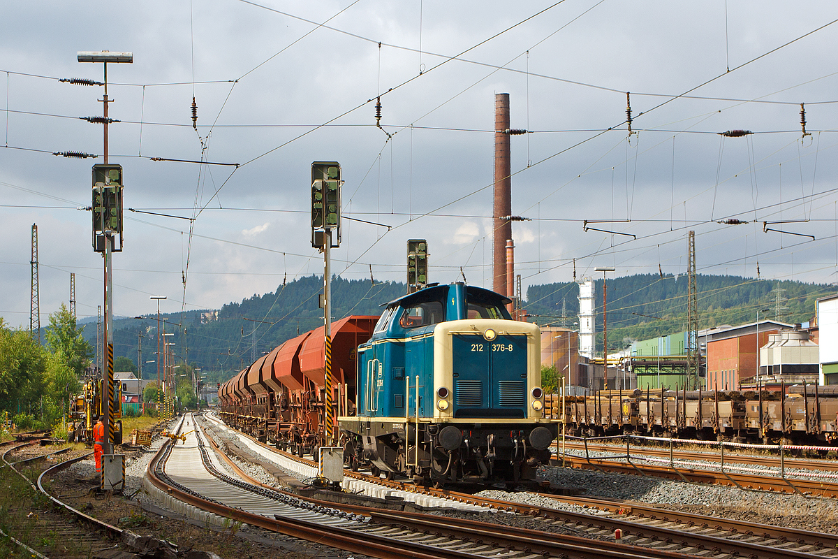 
In Siegen-Geisweid (ehemals Hüttental-Geisweid) werden die Ausweich- und Abstellgleise erneuert.... 
Die 212 376-8 der Aggerbahn (Andreas Voll e.K., Wiehl), ex DB V 100 2376, ex DB 212 376-8, rangiert am 14.07.2014 einen Schotterzug in die Baustelle.  Rechts im Hintergrund das Stahlwerk Geisweid der Deutsche Edelstahlwerke GmbH (ehemals Stahlwerke Südwestfalen).
Übrigens ist das Personal von den Aggerbahn sehr freundlich und nett.

Die Lok, vom Typ V100.20 wurde 1965 bei Deutz unter der Fabrik-Nr. 57776 gebaut und als V 100 2376 an die Deutsche Bundesbahn ausgeliefert, 1968 erfolgte die Umzeichnung in 212 376-8. Die Ausmusterung bei der DB erfolgte 2010, über ALS - ALSTOM Lokomotiven Service GmbH in Stendal kam sie 2011 zur Aggerbahn.
