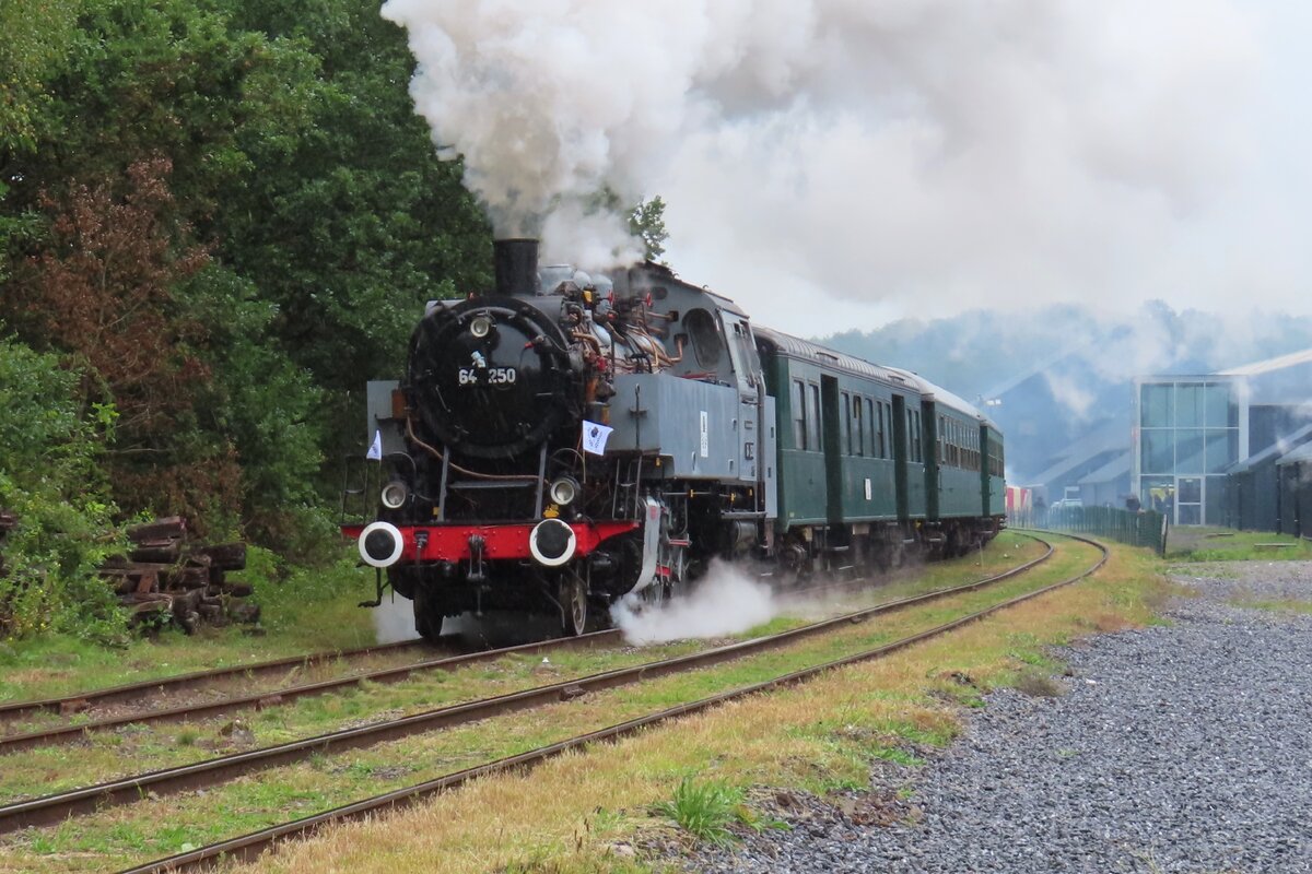 In stromender Regen zieht 64 250 -frisch restauriert- ein Dampfpendelzug nach Mariembourg aus Treignes an verregneten Vormittag von 22 September 2023.