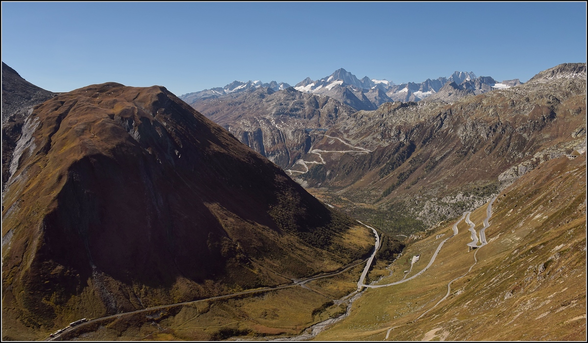 Kommt man über den Furkapass gefahren, so öffnet sich dieser Blick über das Rhonetal und auf die großen Berge des Berner Oberlandes kurz nach der Passhöhe. Doch nach unten geblickt, erkennt man direkt die Furka-Bergstrecke. Mit großem Einsatz vieler freiwilliger Helfer der DFB gepflegt erhalten. Die prominenten Massive im Hintergrund sind Finsteraarhorn in der Mitte sowie Lauteraarhorn und Schreckhorn rechterhand. Sogar die weiße Spitze des Mönchs blickt knapp über den langgezogenen Grat. Oktober 2018.