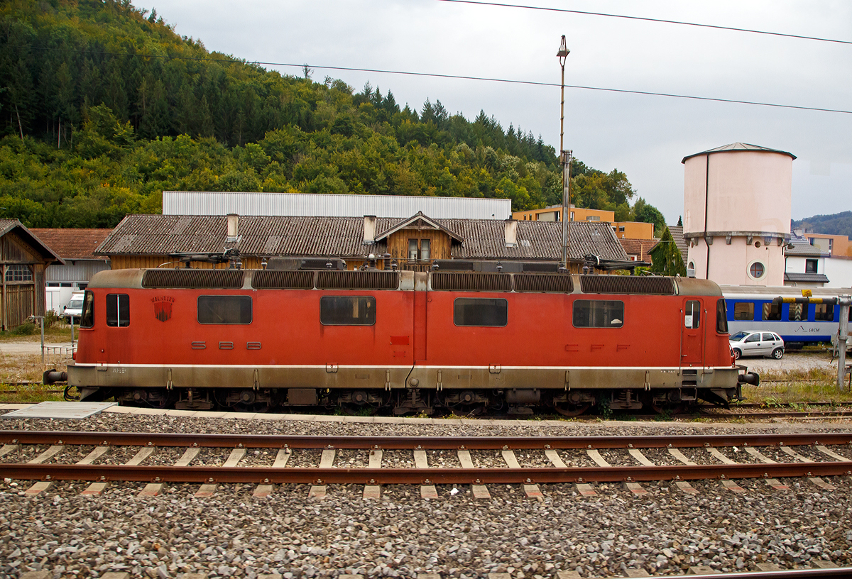 Leider der Beschilderung beraubt...
Die ehemalige SBB Re  6/6 11601  WOLHUSEN , später Re 620 001, eine der beiden Prototypen mit zweiteiligen Kasten, ist am 09.09.2021 abgestellt in Sissach. Aufgenommen aus dem Zug durch die Scheibe. 

Die SBB Re 6/6 Prototypen wurde 1972 von SLM in Winterthur (Schweizerische Lokomotiv- und Maschinenfabrik) gebaut. Im Herbst 2019 wurde bekannt, dass die zweiteiligen Prototypen 11601 und 11602 an eine Privatperson im Umfeld des Vereins Swisstrain verkauft wurden. Es ist geplant, dass die 11601 revidiert und wieder fahrtüchtig gemacht werden soll, die 11602 sollals Ersatzteilspender genutzt werden. Im Oktober 2019 wurde die 11601 deshalb von Bellinzona nach Sissach überführt.

Die Re 6/6, nach neuem Bezeichnungsschema Re 620, sind sechsachsige, elektrische Lokomotiven der Schweizerischen Bundesbahnen (SBB), die als Ersatz für die Ae 6/6 im schweren Dienst am Gotthard angeschafft wurden. Aus den Anforderungen an die Baureihe ergab sich für die Traktion die Notwendigkeit von sechs Triebachsen. Um dennoch gute Kurvenlaufeigenschaften mit niedrigem Verschleiß zu erreichen, wurden im Gegensatz zur Ae 6/6 drei zweiachsige Drehgestelle eingebaut, wobei sich das mittlere stark seitlich bewegen kann. Für einen besseren Kurveneinlauf der nachlaufenden zwei Drehgestelle wurden zusätzlich zwischen den drei Drehgestellen elastische Querkupplungen angeordnet. Dabei basiert die Querkupplung auf dem Prinzip, welches ursprünglich für die Ge 6/6II der Rhätischen Bahn (RhB) entwickelt wurde. Zwei der vier Prototypen (11601 und 11602) erhielten wie die Ge 6/6II der RhB einen geteilten Lokkasten, wobei sich das Gelenk analog zur RhB Ge 6/6II nur vertikal bewegen kann, um sich Gefälleänderungen anzupassen.

Die bei den beiden anderen Prototypen gewählte weichere Sekundärabfederung des mittleren Drehgestells bewährte sich im Versuchsbetrieb, so dass bei der Serienproduktion der einteilige Kasten zur Ausführung kam. Die zwei Prototypen mit geteiltem Kasten wurden aber weiterhin im Regelbetrieb eingesetzt.

Das Design ist der Form der Re 4/4II angelehnt, ebenso die Bedienung und die herkömmliche Trafotechnik, welche bei der Re 6/6 zuletzt eingesetzt wurde. Bei der Re 6/6 sind allerdings zwei Transformatoren (Leistungstransformator und Regeltransformator) vorhanden, die sich im Lokomotivkasten zwischen den Drehgestellen befinden.

TECHNISCHE DATEN (Serie):
Gebaute Stückzahl:  4 Prototypen und 85 Serienmaschinen
Hersteller: 	SLM, BBC, SAAS
Baujahre: 	1972 (Prototypen), 1975–1980 (Serie)
Spurweite:  1.435 mm (Normalspur)
Achsfolge:  Bo'Bo'Bo'
Länge über Puffer: 19.310 mm
Drehzapfenabstände: 5.700 / 5.700 mm
Achsabstand in den Drehgestellen: 2.900 mm
Treibraddurchmesser: 	1.260 mm (neu)
Höhe: 3.932 mm
Breite: 2.950 mm
Dienstgewicht: 120 t
Anzahl der Fahrmotoren: 6
Stundenleistung an der Welle: 6 x 1.338 kW = 8.028 kW
Stundenleistung am Rad: 7.802 KW
Dauerleistung am Rad: 7.244 kW
Höchstgeschwindigkeit: 140 km/h
Getriebeübersetzung: 1: 2,636
Anfahrzugkraft: 395 kN
Stundenzugkraft: 267 kN
Dauerzugkraft: 235 kN
Elektrische Bremse: Nutzstrom
Stromsystem: 15 kV, 16,7 Hz ~
