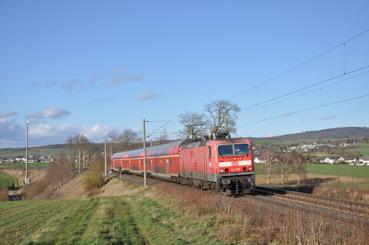 Man könnte zunächst meinen, dass auf diesem Foto eine ganz klassische RB27 auf dem Weg von Rommerskirchen nach Koblenz Hbf ist. Denn genau diese Lok und die Wagen waren ein alltägliches Bild auf der Rhein-Erft-Bahn. Doch wenn man die Gegend näher betrachtet, stellt man fest, dass man sich hier in Hessen befindet: 143 555 fährt mit ihren drei ehemaligen RB27 Doppelstockwagen als RB22 von Limburg(Lahn) nach Frankfurt Hbf und konnte dabei am 25. Februar 2020 in Würges aufgenommen werden. 