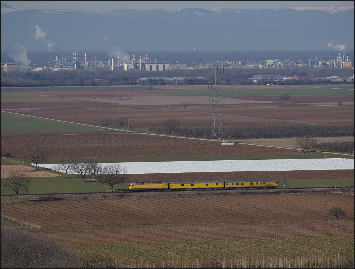 Messzug Nbz 94321 mit 120 160-7 Hockenheim-Basel. Ein Riegel an Industrie markiert die Grenze zu Frankreich. Auggen, Februar 2019.