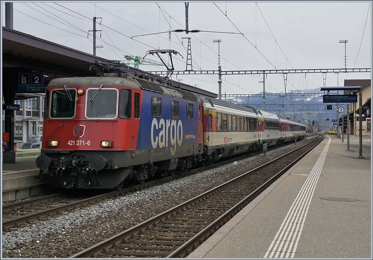 Mit dem breiten Stromabnehmer an der Fahrleitung trifft die SBB Re 421 371-6 mit ihrem in Lindau übernommen EC nach Zürich in St.Margrethen ein. 

14. März 2019