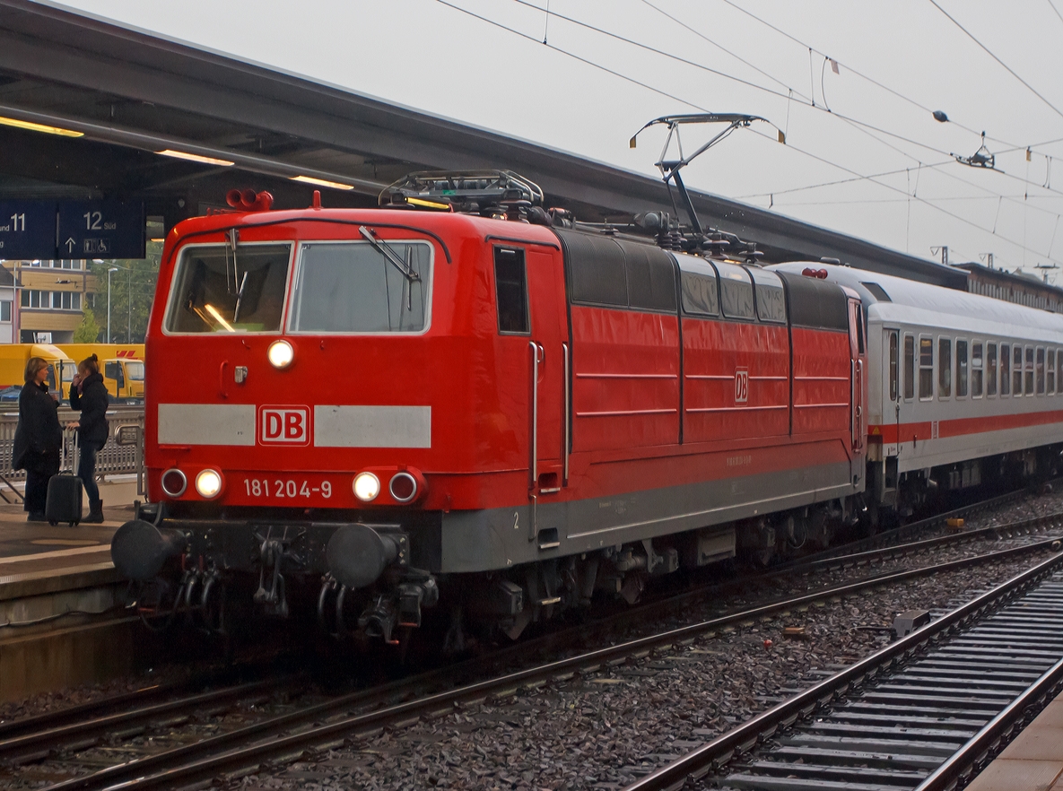 Mit Zehnmentiger Versptung fhrt um 9:17 bei Regen die 181 204-9 mit dem IC 133  Ostfriesland  (Luxembourg - Trier - Koblenz - Kln - Norddeich Mole) in den Hbf Trier ein.  

Noch entlang der Mosel wird der IC bis Koblenz von dieser Zweisystemlokomotive gezogen, in Koblenz wird dann am anderen Zugende dann meist eine 101er angehangen, die den IC dann bis  Norddeich Mole zieht.
Die 181.2er bleiben dann, fr anderen Gegenzug, in Koblenz stehen. 

Von der Lokbaureihe 181.2 wurde 1974 bis 1975 insgesamt 25 Maschinen speziell fr den grenzberschreitenden Verkehr nach Frankreich und Luxemburg beschafft. Diese wurden von Krupp (Mechanischer Teil) und AEG (Elektrischer Teil) gebaut und geliefert. Zudem waren bereit 1966 vier Vorserienlok E 310 (BR 181.0 und 181.1) von Krupp und AEG gebaut worden.
