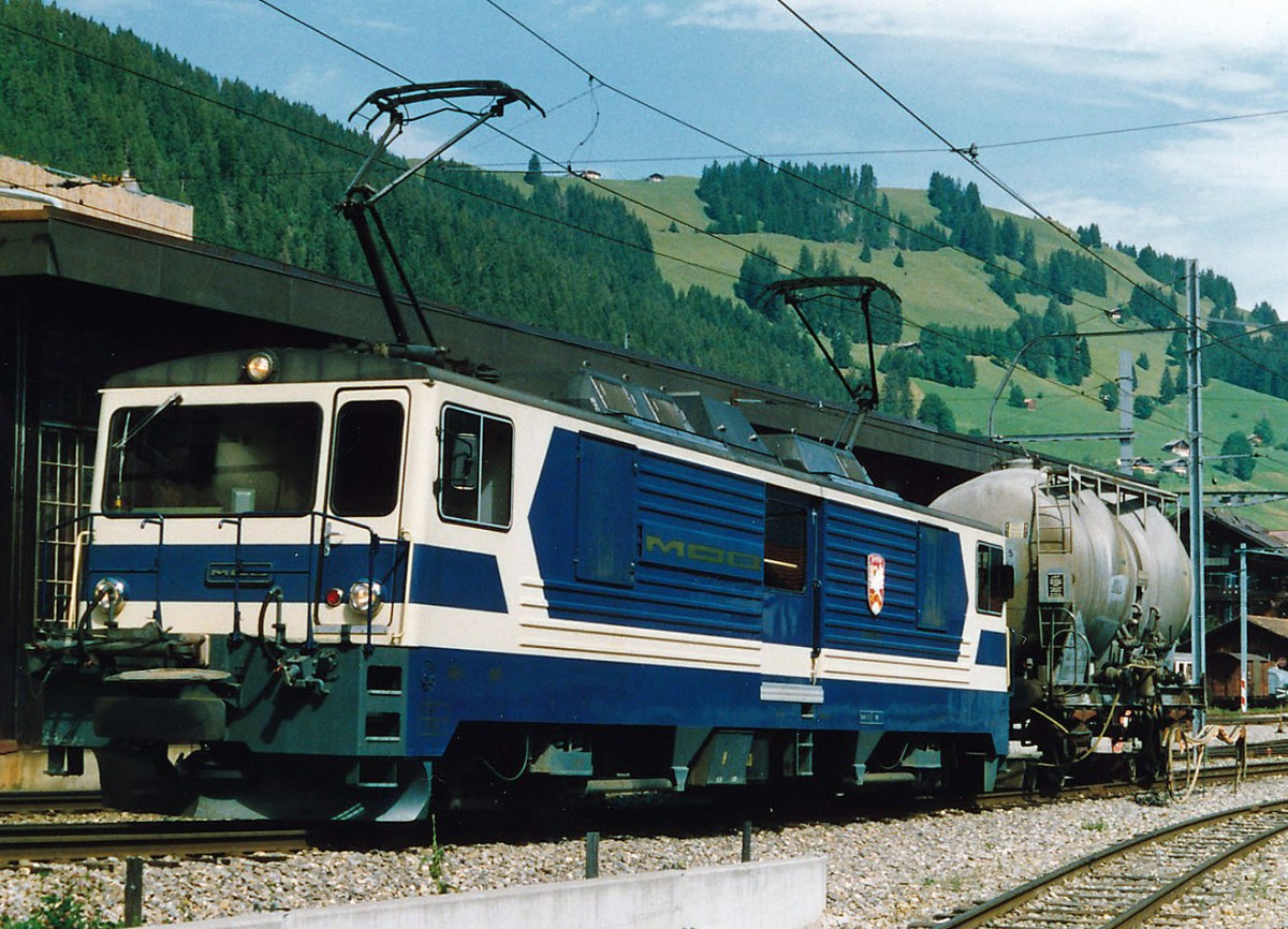 MOB: Whrend den vielen Jahren, da ich die MOB fotografierte, erlebte ich nie einen eihheitlichen Farbanstrich. Bereits die im Jahre 1983 in den Betrieb gestellten GDe 4/4 6001 bis G004 wurden in einem eher dunkelblauen Farbkleid abgeliefert. Bald aber ist die ursprngliche einheitliche Farbgebung durch die verschiedesten Werbeaufschriften verdrngt worden. GDe 4/4 6002 im Ablieferungszustand mit einem Rollbockzug in Zweisimmen im Jahre 1984.
Foto: Walter Ruetsch    