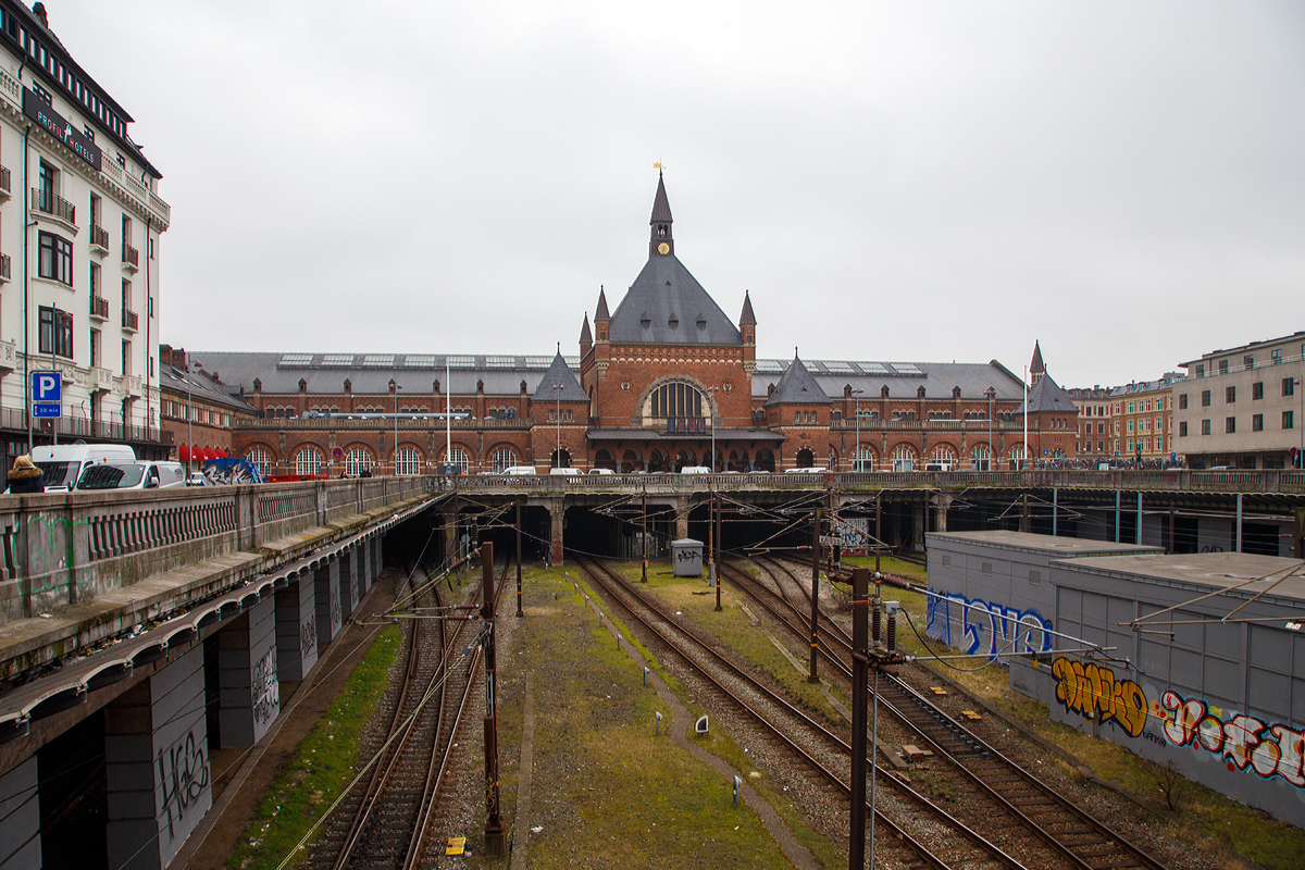 
Nordansicht vom Hauptbahnhof Kopenhagen (dän. Københavns Hovedbanegård) am 20.03.2019.

Københavns Hovedbanegård, abgekürzt København H, ist der Hauptbahnhof von Kopenhagen und wichtigste Fernbahnhof im Streckennetz der Dänischen Staatsbahnen. Er entstand nach einem Entwurf des Architekten Heinrich Wenck und wurde am 1. Dezember 1911 in Betrieb genommen. 

Der heutige Hauptbahnhof hatte zwei Vorgänger-Bahnhöfe an gleicher Stelle. Der erste Bau wurde 1847 errichtet, wobei die Bahnsteiggleise quer zu der heutigen Ausrichtung verliefen. Der zweite Bahnhof wurde als Ersatz für den zu klein gewordenen ersten Bahnhof 1864 eröffnet. Der jetzige Bahnhof war zunächst (wie seine Vorgänger) als reiner Kopfbahnhof angelegt, am 30. November 1911 von König Christian X eingeweiht und am folgenden Tag in Betrieb genommen.

Der heutige Bahnhof befindet sich im Südwesten der Innenstadt im Bereich ehemaliger Wallanlagen am Übergang zum Viertel Vesterbro. Auf der östlichen Seite schließt sich unmittelbar der innerstädtische Vergnügungspark Tivoli an. Gegenüber dem Hauptportal, an der Vesterbrogade, steht die 1797 errichtete Freiheitssäule, die an die Aufhebung der Leibeigenschaft in Dänemark erinnert.

Das Empfangsgebäude des jetzigen Durchgangsbahnhofes befindet sich wie schon zu Beginn nördlich quer zu den Gleisen, die beim heutigen Stand unter dem erhöhten Bahnhofsvorplatz und durch einen Tunnel hindurch in Richtung Norden bzw. Helsingør weitergeführt werden. Dadurch entsteht im Stadtbild weiterhin der Eindruck eines Kopfbahnhofes. Die Tunnelstrecke wird neben den Zügen nach Nord-Seeland auch vom S-tog-System befahren. Die wichtigsten Fernverkehrsstrecken (Öresundverbindung, Vestbanen nach Fredericia, Vogelfluglinie) erreichen den Hauptbahnhof jedoch von Süden. Der Bahnhof hat 13 Bahnsteiggleise, von denen die Gleise 1 bis 8 und 26 für den Regional- und Fernverkehr genutzt werden, die Gleise 9 bis 12 von der S-Bahn Kopenhagen (S-tog).
