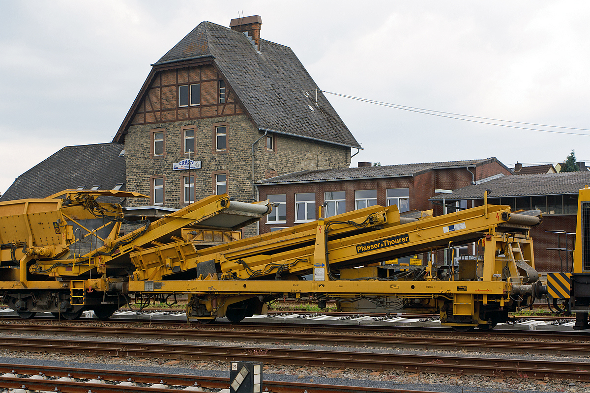 
Plasser & Theurer Beladestation BLS 2000 (Schweres Nebenfahrzeug Nr. 97 19 26 502 57-8) der Hering Bau, Burbach, abgestellt am 02.08.2014 im Bahnhof Sierhahn (Westerwald). 

Um Schüttgüter mittels Erdbaugeräten (Bagger etc.) in MFS-Einheiten fördern zu können, ist die Beladestation entwickelt worden. Sie besteht aus Schottertrichter, breitem Kettenförderband und hydraulisch ein- und ausfahrbarem Übergabeförderband mit Schwenkeinrichtung für die Arbeit im Gleisbogen. 
Die BLS 2000 ist ein zweiachsiges, gleisfahrbares Gerät. Zur leichteren Beladung kann der Schottertrichter während der Arbeit hydraulisch abgesenkt werden. 

Technische Daten:
Achsanzahl: 2
Eigengewicht:  22.300 kg
Länge über Puffer: 12.900 mm
Achsabstand: 8.000 mm
Höchstgeschwindigkeit: 100 km
