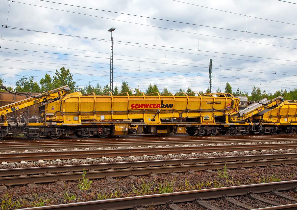 
Plasser & Theurer Materialförder- und Siloeinheit MFS 100 der Schweerbau (Schweres Nebenfahrzeug Nr. 97 19 34 552 57-3) am 17.06.2017 in Koblenz-Lützel.

Die MFS 100 und dienen zum Transport von Schotter, Abraum und Pufferspeicher bei der Bettungsreinigung bzw. Planumsverbesserung. Hauptvorteil ist der kontinuierliche Förder-, Speicher- und Entladevorgang. Eine Zusammenstellung von beliebig vielen MFS-Wagen zu einem Zug mit jeweils gewünschter Speicherkapazität ist möglich. Der Füllvorgang beginnt beim vordersten Wagen (in Arbeitsrichtung), die folgenden Wagen dienen als Förderstraße.

Technische Daten: 
Länge über Puffer 22.900 mm 
Länge inkl. Förderband 26.550 mm
Achszahl 8 (2 Drehgestelle mit je 4 Achsen) 
Drehzapfenabstände: 3.900 mm / 11.200 mm / 3.900 mm
Achsabstand in den Drehgestellen: 1.500 mm 
Laufraddurchmesser: 850 mm
max. Achslast (beladen) 18t 
Eigengewicht: 60 t 
max. zulässige Zuladung 84 t (Streckenklasse D4) 
Motorleistung: 160 kW für Antrieb der Förderbänder 
max. Geschwindigkeit im Zugverband 100 km/h 
max. Fassungsvermögen 68 m³
Bandgeschwindigkeit: Bodenband 0,00 - 0,55 m/s; Übergabeband 0,00 - 1,20 m/s
Förderleistung: 0 – 800 m³/h
