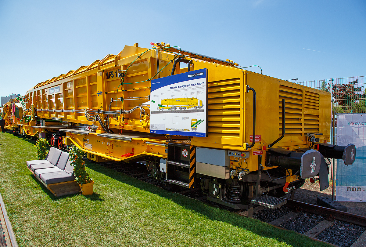 Plasser & Theurer Materialförder- und Siloeinheit MFS 120, Schweres-Nebenfahrzeug-Nr. 99 81 9352 085-0 A-PLA, der Franz Plasser Vermietung von Bahnbaumaschinen GmbH, präsentiert auf der iaf 2017 in Münster (am 01.06.2017).

Die Materialförder- und Siloeinheit MFS 120 wurde 2017 von Plasser & Theurer  in Linz (A) unter der Fabriknummer 6540 gebaut-

Die Materialförder- und Siloeinheit ist zum kontinuierlichen Be- und Entladen. Die MFS 120 sind für optimiertes Fördern, Speichern. Entladen bis 68 m³ mit schwenkbarem Übergabeförderband ausgestattet. Sie kann gleichzeitig beladen und entladen werden. Die Steuerung kann hierbei auch über eine Fernbedienung erfolgen. Das schwenkbare Übergabeförderband ermöglicht den Materialtransport zum nächsten Wagen oder in geschwenkter Stellung neben das Gleis. Als Neuheit besteht die Möglichkeit, das Übergabeförderband in das Drehgestell zu versenken. Beim Abtransport der Wagen kann so auf den bislang notwendigen Schutzwagen verzichtet werden. Die MFS 120 sind kompatibel zu den bisherigen Wagen (z.B. MFS 100).

Materialförder- und Siloeinheiten dienen zum Transport von Schotter, Abraum und Pufferspeicher bei der Bettungsreinigung bzw. Planumsverbesserung. Hauptvorteil ist der kontinuierliche Förder-, Speicher- und Entladevorgang. Eine Zusammenstellung von beliebig vielen MFS-Wagen zu einem Zug mit jeweils gewünschter Speicherkapazität ist möglich. Der Füllvorgang beginnt beim vordersten Wagen (in Arbeitsrichtung), die folgenden Wagen dienen als Förderstraße.

TECHNISCHE DATEN:
Spurweite: 1.435 mm
Achsanzahl : 8 (in 4 Drehgestellen)
Länge über Puffer: 22.900 mm
Gesamtlänge mit ausgefahrenem Förderband: ca. 26 640 mm
Drehzapfenabstände: 6.650 m / 4.800 mm / 6.650 m
Achsabstand in den Drehgestellen: 1.800 mm
Laufraddurchmesser: 920 mm (neu)
Höhe:  4.165 mm (Arbeit) / 3 974 mm (Schleppfahrt)
Breite:  3.183mm
Leergewicht: 65.000 kg
Siloinhalt (theoretisch): 68 m³
Nutzlast:  80,5 t (ab C2) / 98,6 t (ab D 3) / 112,5 t (ab D 4)
Höchstgeschwindigkeit: 100 km/h 
Bremse: KP-GE-A (Max. 147 t)
Handbremse: Ja (einzeln auf 2 Drehgestelle)
Kleister befahrbarer Gleisbogen: R = 150 mm
Diesel-Motorleistung: 129 kW (für Hydraulische Antriebe)
Schwenkbereich des Übergabebandes: ±45°
Förderbandbreiten (Bodenförderband):  1.980 mm
Förderbandbreiten (Übergabeband):  1.900 mm