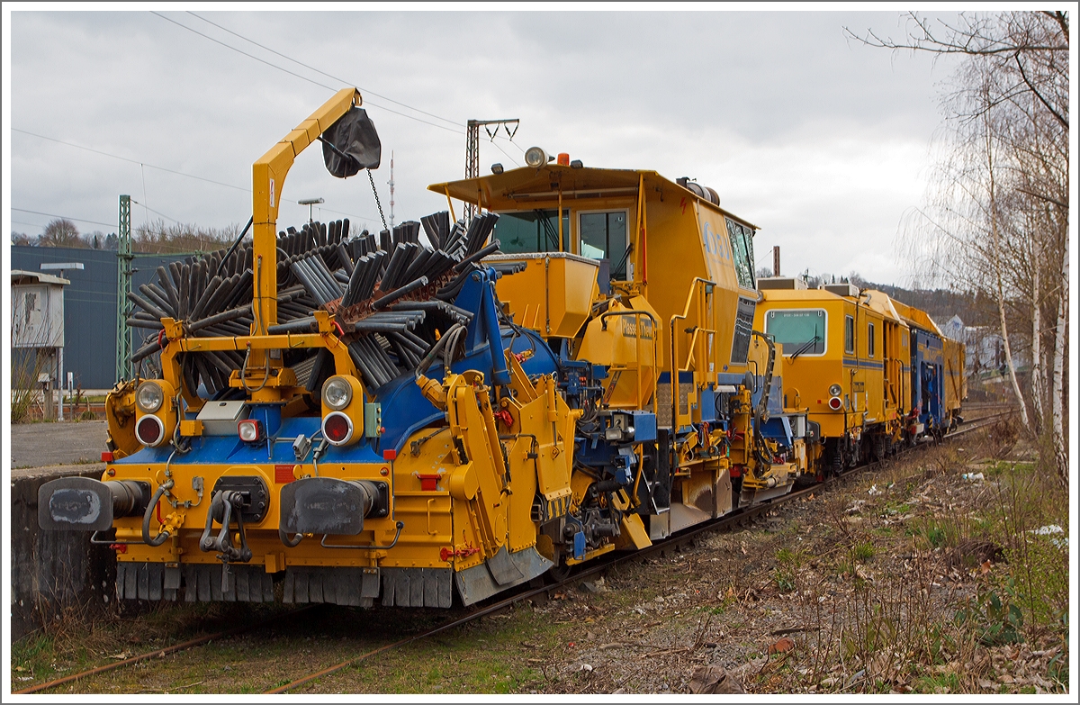 Plasser & Theurer Schnellschotterplaniermaschine SSP 110 SW  (Schweres Nebenfahrzeug Nr. 97 16 46 516 18-9) sowie dahinter die Plasser und Theurer Universalstopfmaschine (Nivellier-, Hebe-, Richt- und Stopfmaschinen) Unimat 09-475/4S (Schweres Nebenfahrzeug Nr. 99 80 9424 001-2) der DGU - Deutsche Gleisbau Union (Koblenz), abgestellt am 15.03.2014 beim Bahnhof Siegen-Weidenau.