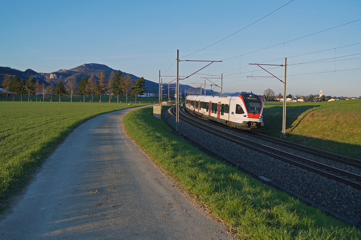 SBB:  STRASSE UND SCHIENE  Ein Flirt als Regionalzug Olten - Solothurn zwischen Niederbipp und Wangen an der Aare am 8. April 2015 im letzten Abendlicht unterwegs.
Foto: Walter Ruetsch