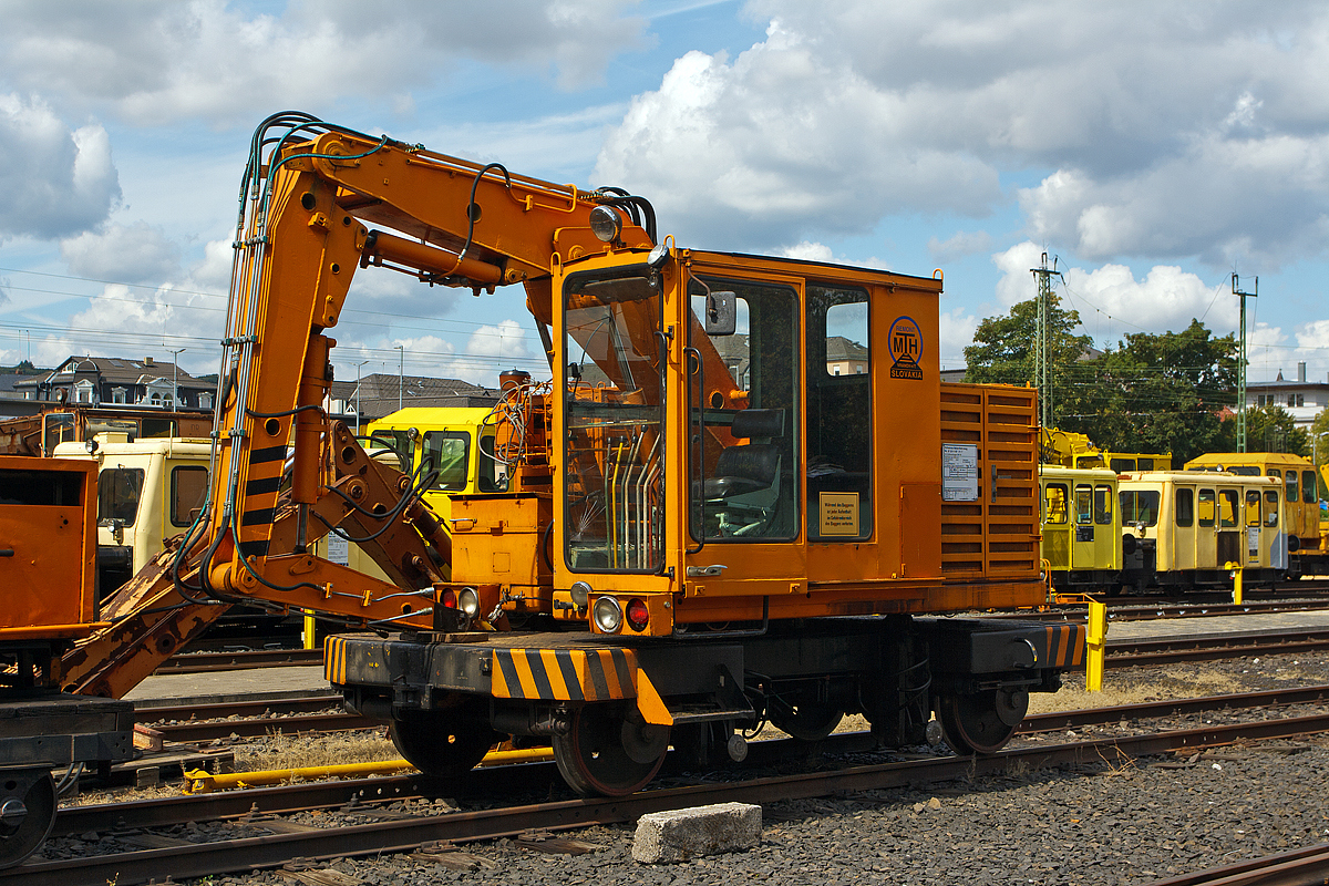 
Schienenbagger SVP 60 (auch Schwellenwechselmaschine SVP 60) der Eisenbahnfreunde Wetterau e.V., Schweres Nebenfahrzeug 97 20 11 107 21-7, auf dem Vereinsgelnde in Bad Nauheim am 20.08.2014.

Der Schienenbagger wurde 1986 von MTH REMONT, s.r.o. Vranov nad Topľou (Slowakei) unter der Fabriknummer 61 gebaut und als SWM 21 an die DR (Deutsche Reichsbahn) geliefert.  
Hinweis: Aufnahme vom Gehweg ber den Zaun hinweg.

Technische Daten:
Spurweite: 1.435 mm
Eigengewicht:  12,0 t
Hchstgeschwindigkeit (Hg):  60 km/h
Zur Mitfahrt zugel. Personen: 3 (einschl. Fahrer)
Fahrantrieb: Hydraulisch
 
Mit einen Anbaugert knnen mit diesem Fahrzeug einzelne Schwellen gewechselt werden. Siehe: http://www.mth.sk/video/svp_2.mpg
