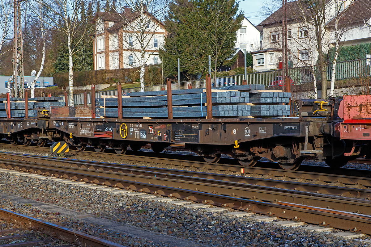 Sechsachsiger Drehgestell-Flachwagen, mit Rungen, Stirnwandklappen und klappbaren Ladeschwellen, jedoch ohne Seitenwandklappen, 31 80 4865 081-2 D-DB, der Gattung Samms 709, beladen mit Stahlknppel (Vierkantstangen), am 22.12.2021 im Zugverband bei einer Zugdurchfahrt in Kreuztal. Hier im Bild sind je Lngsseite 4 Rungen eingesteckt, je 2 Rungen lagern in Taschen an den Auenlangtrgern (hier im Bild links vom Handrad der Festellbremse).

Der Wagen dient mit aufgeklappten Ladeschwellen zur Befrderung von schweren Walzprofilen und anderen sperrigen Gtern. Mit eingeklappten Ladeschwellen, also mit ebener Ladeebene, eignen sich die Wagen mit dem Nummernkreis 31 80 4865 000-2 bis 999-5 auch zum Transport schwerer Kettenfahrzeuge. Fr das Be- und Entladen dieser Fahrzeuge sind befahrbare Stirnwandklappen und Absttzungen vorhanden. Bei den brigen Wagen dieser Bauart wurden die Absttzungen stillgelegt.Wobei hier im Bild sind die Ladeschwellen eingeklappt, stattdessen wurden Vierkanthlzer auf den flachen Wagenboden untergelegt.

Die Wagenbrcke ist eine in Rahmenbauweise ausgefhrte Schweikonstruktion, deren Hauptbauteile aus St 52 bestehen. Die Hauptbelastungen werden von den ueren Langtrgern aus IPE 600 aufgenommen. Die Puffertrger sind so ausgebildet, dass spter ohne groe nderungen die AK eingebaut werden kann.

Der Fuboden besteht aus Kiefernbohlen mit den Abmessungen 70 x 200 mm; er kann eine Radlast von 5,0 t aufnehmen. Im Fuboden sind 6 geteilte klappbare Ladeschwellen eingebaut. Das Fahrzeug hat auf jeder Lngsseite 6 Einsteckrungen und an jeder Stirnseite je 2 versenkbare Rungen (Fallrungen). Die Stirnwandklappen sind umlegbar. Die Einsteckrungen lagern, wenn sie nicht gebraucht werden, in Taschen an den Auenlangtrgern. Die abgesenkten Fallrungen liegen noch innerhalb des Umgrenzungsprofils, so dass der Wagen auch mit abgesenkten Fallrungen und umgelegten Stirnwandklappen gefahren werden kann. Die Wagen sind mit einer bodenbedienbaren Feststellbremse ausgerstet. 

TECHNISCHE DATEN:
Gattung: Samms 709 (Gattungskennzahl 4865)
Erstes Baujahr: 1977
Spurweite: 1.435 mm (Normalspur)
Lnge ber Puffer: 16.400 mm
Drehzapfenabstand: 9.150 mm
Radsatzstand in den Drehgestellen: 2 x 1.700 mm = 3.400 mm
Drehgestell-Typ: BA 711.5
Ladelnge: 15.000 mm
Ladebreite: 2.585 mm (zwischen den Rungen)
Fubodenhhe ber SO: 1.200 mm
Ladeflche: 46 m
Eigengewicht: 30.360 kg
Zuladung bei Lastgrenze S: 74,5 t (ab Streckenklasse D)
Zuladung auf DB Netz bei Streckenklasse CE/D: 89.5 t (max.100 km/h)
Max. Zuladung: 101,5 t
Max. Geschwindigkeit: 100 km/h (beladen) / 120 km/h (leer)
Kleinster Gleisbogenhalbmesser: 75 m
Bauart der Bremse: KE-GP (LL) 
Bremssohle: IP 116
Handbremse: Ja
Internationale Verwendungsfhigkeit: RIV
