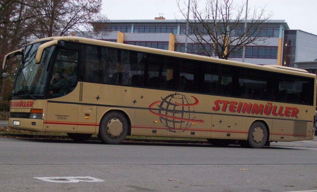 Setra S 315 GT von Steinmller Reisen, Waldkraiburg (heute: Hofstetter Reisen, Bad Endorf). Der aus Frankreich stammende Kombibus ist vom Baujahr 1995, verfgt ber 57+1 Sitzpltze (EC-Schlafbestuhlung, kippbare Sitzbank am Mitteleinstieg) und als Antrieb ber einen V6 Typ MB OM 441 LA mit 250 kW (340 PS) sowie ein pneumatisches Schaltgetriebe mit acht Gngen ( Doppel-H-Schaltung ), Typ ZF 8 S-180. Anfang 2014 wurde der Bus an Hogger Reisen aus Freilassing abgegeben.
Die Aufnahme entstand am 12. 11. 2012 in Waldkraiburg, Franz-Liszt-Strae (Schulzentrum), wo er zur Abfahrt auf der RBO-Linie 7510 Kurs 003 in Richtung Heldenstein/Haigerloh bereitstand.