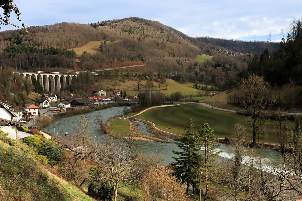 St.Ursanne, mit dem grossen Eisenbahn-Viadukt und Blick auf den Doubs und die obersten Häuser von St.Ursanne. Der SBB-Flirt wird bald im Tunnel verschwinden unterwegs nach Glovelier und Delémont. 18.Februar 2022  