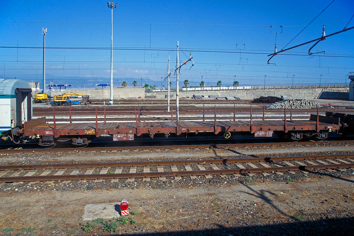 Vierachsiger Drehgestell-Flachwagen 31 83 3916 043-0 I-MIR der Gattung Rgs, der Mercitalia Rail Srl, am 20.07.2022 im Bahnhof Messina Centrale als Schutzwagen für das Trajekt-Manöver, vor der D.145.2037 und einem weiteren Flachwagen, sowie hinter einem  2. Klasse MDVC-Reisezugwagen.

TECHNISCHE DATEN: 
Spurweite: 1.435 mm (Normalspur)
Anzahl der Achsen: 4 (in 2 Drehgestellen)
Länge über Puffer:  19.900 mm
Drehzapfenabstand:  14.860 mm
Achsabstand im Drehgestell: 1.800 mm
Länge der Ladefläche: 18.500 mm 
Höhe der Lädefläche: 1.170 mm
Ladefläche: 51,5 m²
Eigengewicht:  23.400 kg
Max. Zuladung: 56 t (ab Streckenklasse C)
Max. Geschwindigkeit: 100 km/h / leer 120 km/h
Bremse: Freno Wu-GP
Feststellbremse: Ja
Verwendungsfähigkeit: RIV