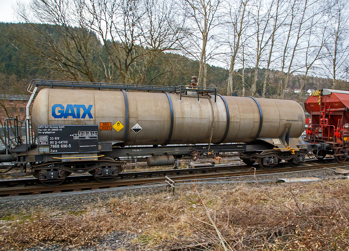 Vierachsiger-Drehgestell Kesselwagen für Salpetersäure (>98%), der Gattung Zacs, registriert als 33 80 7868 696-5 D- GATXD der GATX Rail Germany GmbH am 06.02.2017 in Herdorf, im Zugverband eines Übergabezuges der KSW.

Die Gefahrguttafel (885/2031)  zeigt es auch noch an: (oben) Gefahrgutnummer 885 = stark ätzender Stoff / (unten) UN-Nummer 2031 = Salpetersäure, andere als rotrauchend, mit mehr als 70 % Säurebrandfördernd. Hier sogar (laut Anschrift) größer 97 %.
Die reine Säure ist farblos und hat einen scharf stechenden Geruch. Sie wird unter anderem zur Herstellung von Sprengstoffen verwendet.

TECHNISCHE DATEN:
Gattung: Zacs
Spurweite: 1.435 mm
Länge über Puffer : 14.240 mm
Drehzapfenabstand: 9.200 mm
Achsabstand im Drehgestell: 1.800 mm
Höchstgeschwindigkeit: 100 km/h (120 km/h leer)
Eigengewicht: 21.530 kg
Nutzlast: 58,4 t ab Streckenklasse C
Gesamtvolumen: 44.900 Liter
Prüfdruck: 4 bar
Zulässiger  Betriebsüberdurck: 3 bar
Tankcode: L10DH
Behälterwerkstoff : Edelstahl
Bremse: KG-GP
Intern. Verwendungsfähigkeit:  RIV