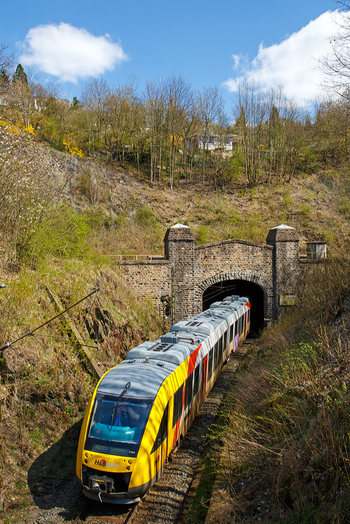 
VT 265 (95 80 0648 165-8 D-HEB /95 80 0648 665-7 D-HEB) der HLB Hessenbahn GmbH (Betreiber der DreiLänderBahn), ein Dieseltriebwagen vom Typ Alstom Coradia LINT 41, kommt hier  gerade am 15.03.2014 aus dem eingleisigen Giersberg-Tunnel (732 m lang).

Er befährt hier die DB Streckennummer 2881 (KBS 445 - Dillstrecke) und erreicht bald den Hbf Siegen.

Über dem hier gezeigten Tunnelportal verläuft die DB Streckennummer 2880 zwischen Siegen-Ost und dem Bahnhof Siegen-Weidenau (rechts liegt der Ausgang vom zweigleisigen 699 m langen Giersbergtunnel). Der Giersbergtunnel wurde 1912 bis 1915 erbaut. Namensgeber ist der 358 Meter hohe Giersberg im östlichen Stadtgebiet von Siegen. Dieser wird vom Giersbergtunnel in zwei getrennten, einander kreuzenden Tunnelröhren durchquert. Die Gleisstrecken der Röhren bilden an zwei getrennten Portalen auf der nordwestlichen Seite des Tunnels den Anschluss an zwei Schenkel eines Gleisdreiecks. Der Giersbergtunnel zählt wegen der einander kreuzenden Röhren zu den Überwerfungsbauwerken und ist der einzige Eisenbahntunnel dieser Bauart in Deutschland. Beide Tunnelstrecken wurden am 1. Dezember 1915 in Betrieb genommen.