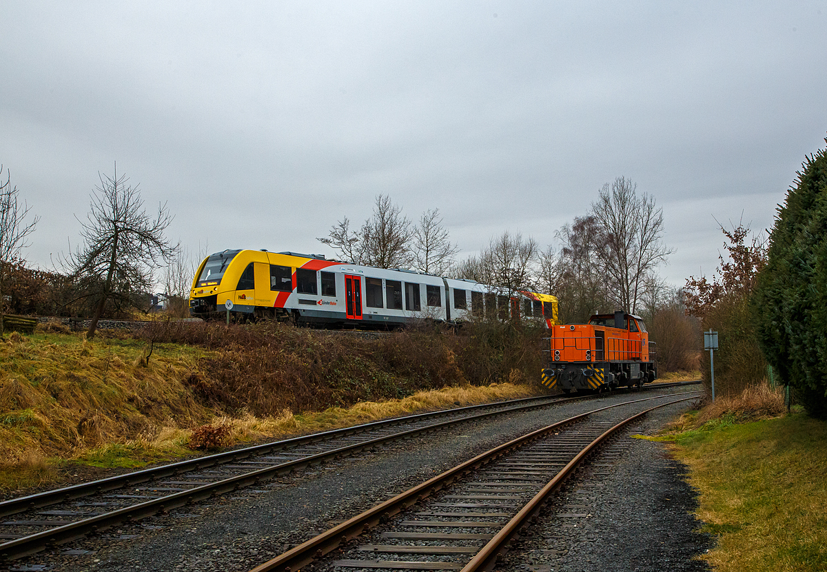 Während oben auf der Hellertalbahn (KBS 462 – DB Bahnstrecke Betzdorf-Haiger) der VT 507 (95 80 1648 107-8 D-HEB / 95 80 1648 607-7 D-HEB) der HLB (Hessische Landesbahn GmbH), ein Alstom Coradia LINT 41 der neuen Generation, als RB 96  Hellertalbahn  (Betzdorf - Herdorf - Neunkirchen - Haiger – Dillenburg), am 12.01.2022 von Herdorf weiter in Richtung Neunkirchen bzw. Haiger fährt. Steht unten auf dem KSW Rangierbahnhof Herdorf (Betriebsstätte Freien Grunder Eisenbahn KSW NE447 / DB-Nr. 9275), nähe dem Lokschuppen (nicht im Bild), die KSW 42 (92 80 1277 902-3 D-KSW), eine Vossloh MaK G 1700 BB der KSW (Kreisbahn Siegen-Wittgenstein).