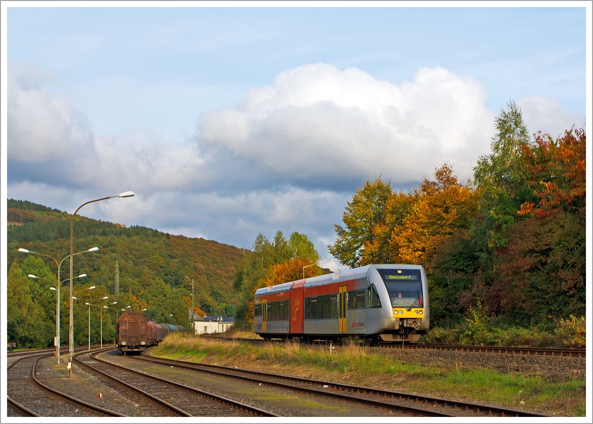 Wenn die Sonne mal durchkommt, so  gibt es ein kleinwenig goldenen Oktober...

Der Stadler GTW 2/6 VT 118 der Hellertalbahn als RB 96 Betzdorf-Herdorf-Neunkirchen, hier am 13.10.2013 kurz vor dem Bahnhof Herdorf.

Er fhrt als RB 96 (Hellertalbahn) die Verbindung Dillenburg-Haiger-Burbach-Neunkirchen-Herdorf-Betzdorf/Sieg (Umlauf HTB90426), ber die gleichnamentliche Strecke Hellertalbahn (KBS 462).

Im Vordergrund der Rangierbahnhof der KSW Kreisbahn Siegen-Wittgenstein (ehem. Freien Grunder Eisenbahn AG), hier ist Sonntagsruhe, es sind nur einige Wagen fr Coiltransporte der Gattung Shimmns abgestellt.
